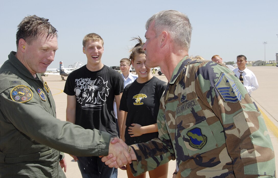 Col. Jeffrey Kendall, 80th Flying Training Wing commander, greets Master Sgt. John Myers, 80th FTW first sergeant, after the colonel's fini-flight Aug. 9. (U.S. Air Force photo/Sandy Wassenmiller)