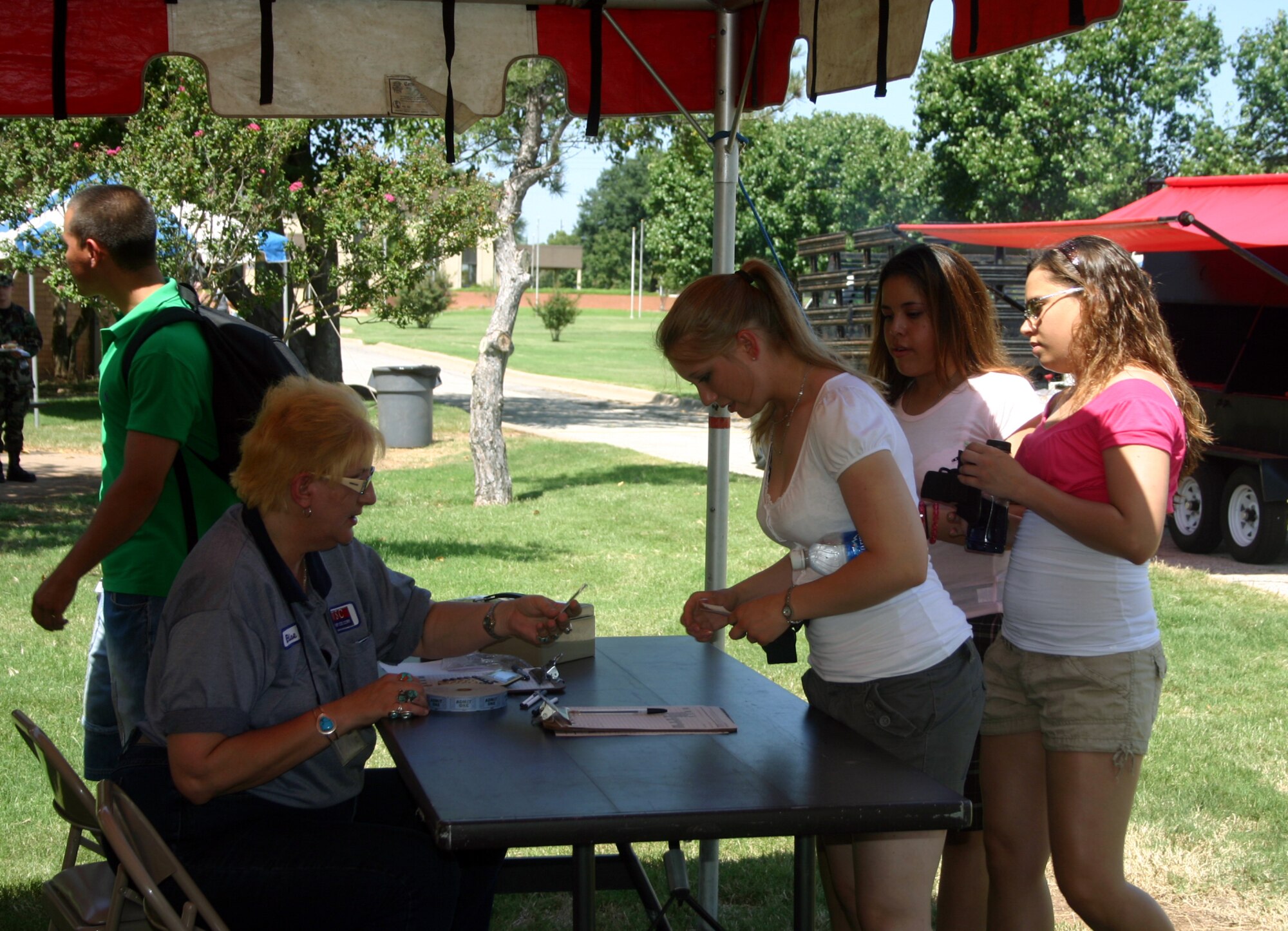 Bronwyn Bradford, an employee with Work Services Corp., admits 363rd Training Squadron's Airman Heather Brant for a free meal at the Airman Appreciation Cookout, held at the Community Activity Center Aug. 11.  The barbecue is held every month for Airmen-in-Training here. (U.S. Air Force photo/Staff Sgt. Tonnette Thompson)