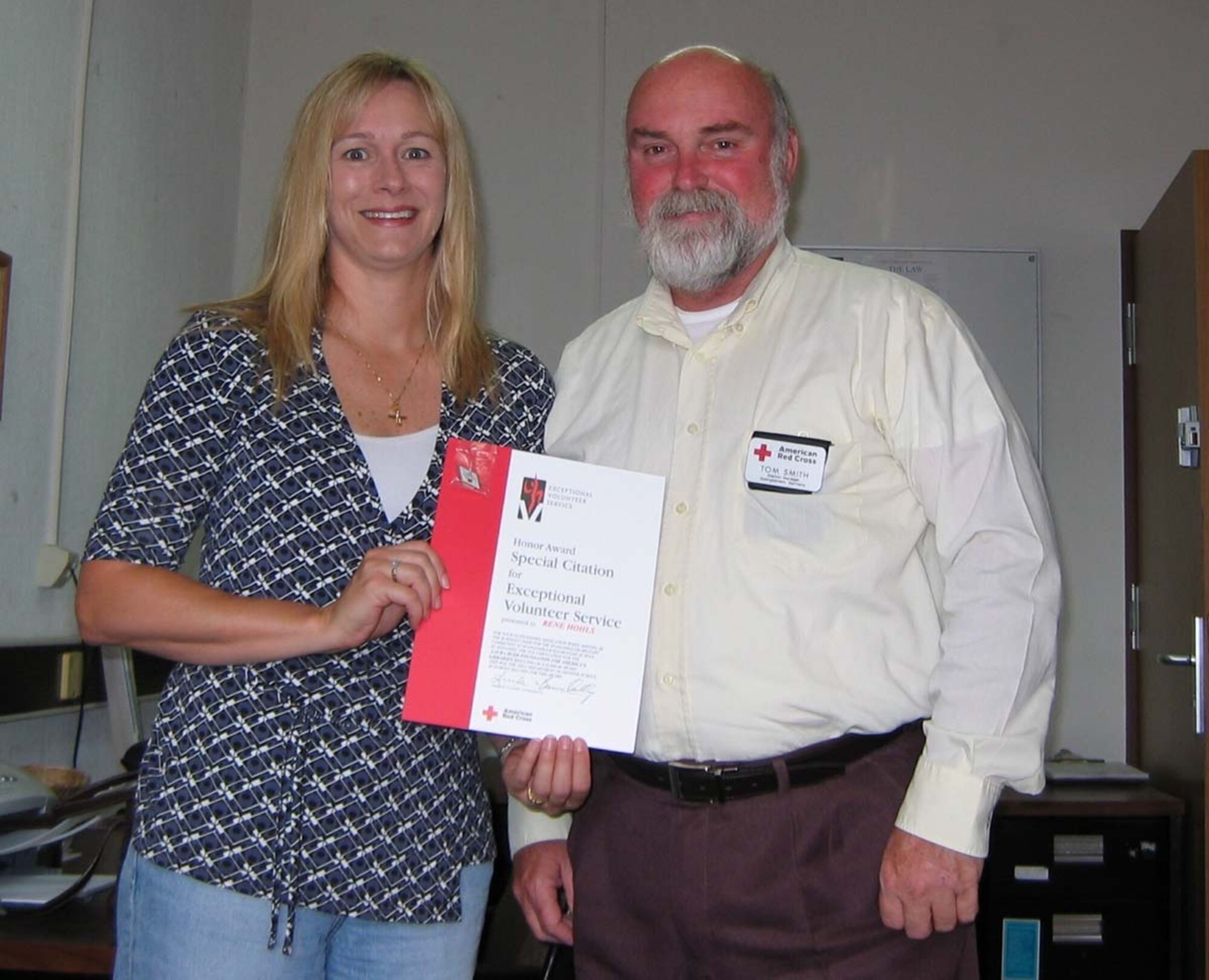 SPANGDAHLEM AIR BASE, Germany -- Rene Hohls receives an American Red Cross Exceptional Volunteer Award from Tom Smith, Red Cross station manager, for her outstanding work within the Spangdahlem Air Base community during the past two years. Mrs. Hohls served as the Schools Chair human resource chair and participated in multiple community activities while representing the Red Cross. Mrs. Hohls is the Level 1 winner of the Armed Forces Emergency Services Award for her assistance to the Spangdahlem Elementary School which was selected for the Laura Bush Foundation for America’s Libraries award of $5,000. Mrs. Hohls’s award package will be forwarded to the Level II competition. (Courtesy photo)