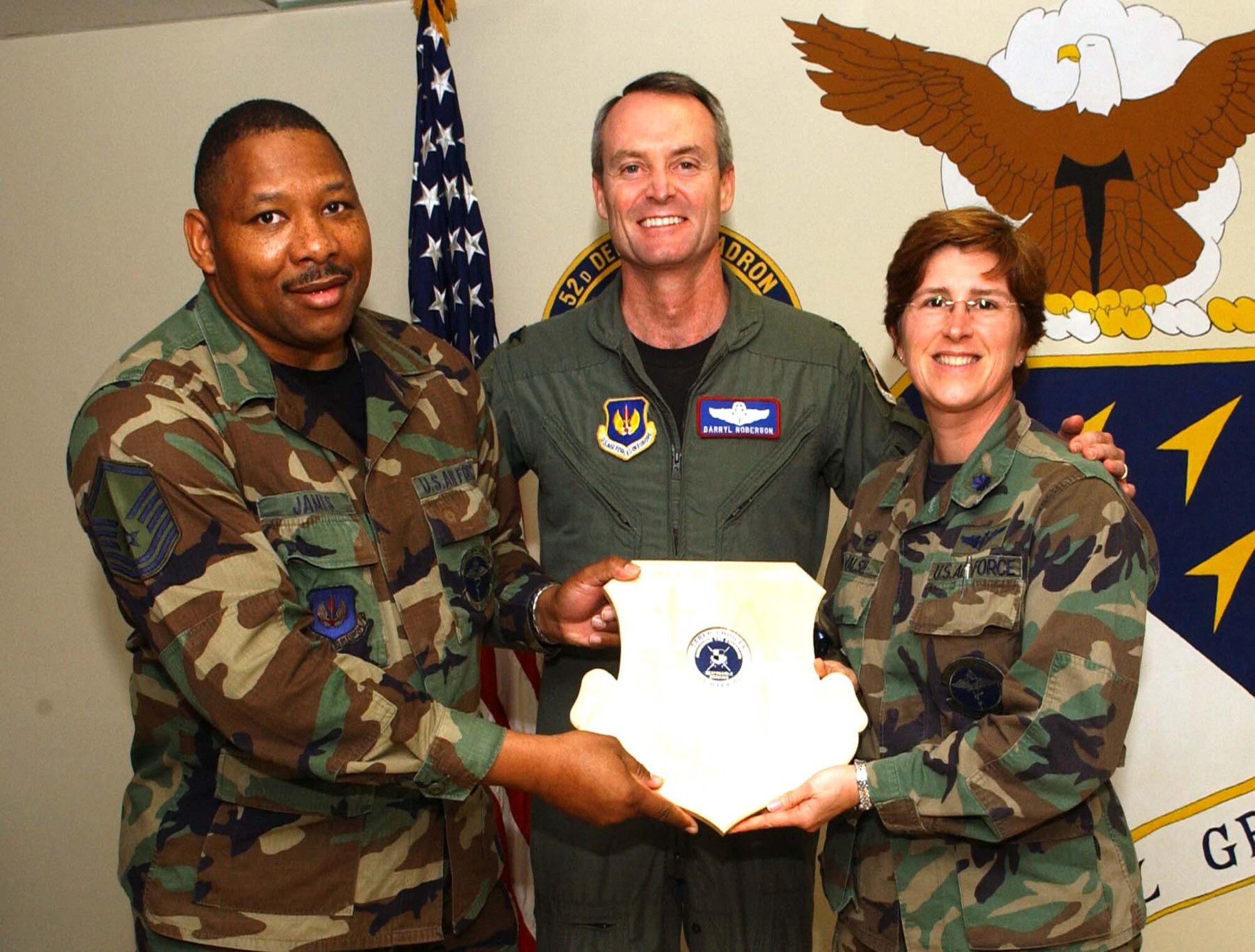 SPANGDAHLEM AIR BASE, Germany -- Col. Darryl Roberson, 52nd Fighter Wing commander, presents a Saber Responsible Choices plaque to Master Sgt. Barry James and Lt. Col. Margaret Walsh, both from the 52nd Medical Operations Squadron, Aug. 9. The plaque with the coin in place symbolizes that the unit has gone more than 52 days with out a squadron member receiving a driving under the influence charge or an alcohol related incident. The medical group has gone more than two years without any ARIs or DUIs.  (US Air Force photo/Airman 1st Class Allen Pollard)   
