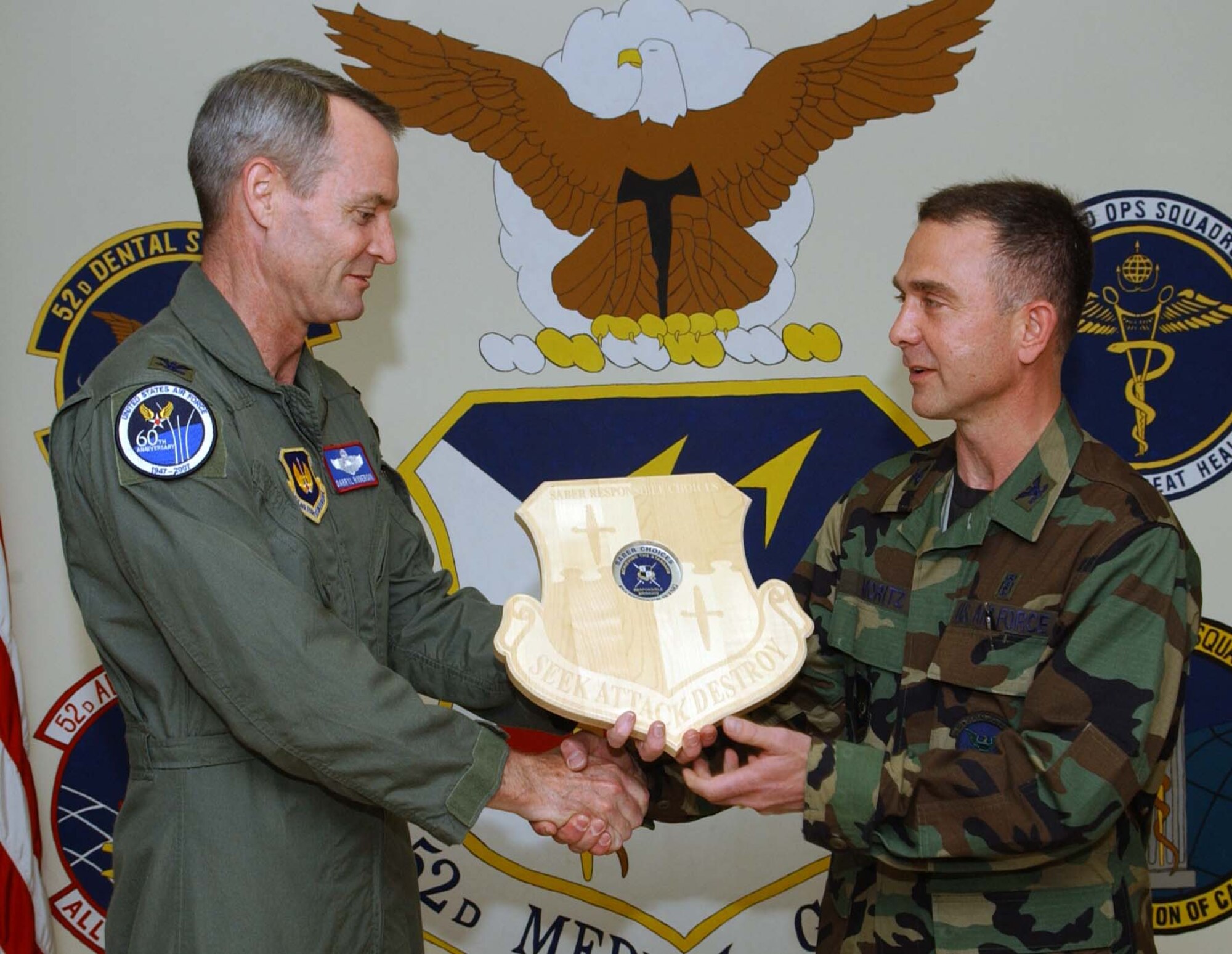 SPANGDAHLEM AIR BASE, Germany -- Col. Darryl Roberson, 52nd Fighter Wing commander, presents a Saber Responsible Choices plaque to Col. Alan Moritz, 52nd Dental Squadron, Aug. 9. The plaque with the coin in place symbolizes that the unit has gone more than 52 days with out a squadron member receiving a driving under the influence charge or an alcohol related incident. The medical group has gone more than two years without any ARIs or DUIs.  (US Air Force photo/Airman 1st Class Allen Pollard)