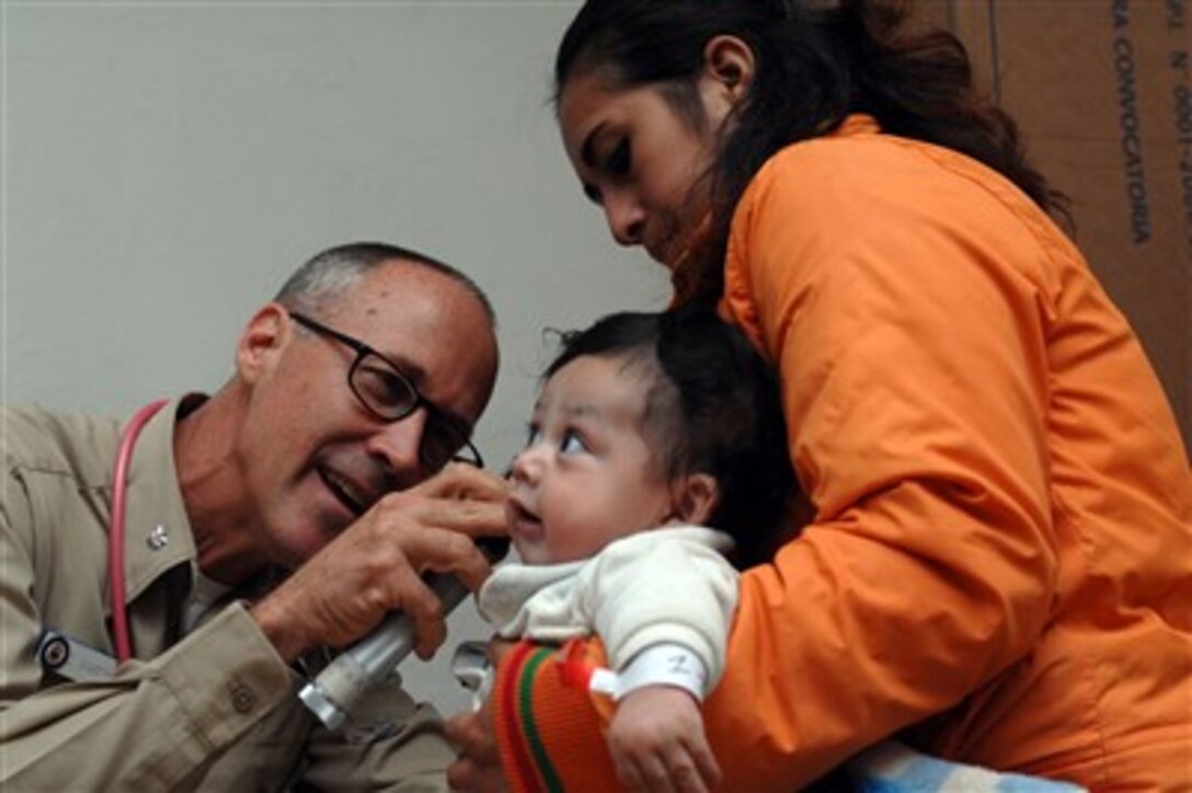 U.S. Navy Cmdr. Craig Martin examines a baby at the Jose F. Sanchez Carrion School in Trujillo, Peru, on Aug. 9, 2007.  Martin is attached to the hospital ship USNS Comfort (T-AH 20).  The Military Sealift Command hospital ship is on a four-month humanitarian deployment to Latin America and the Caribbean to provide medical treatment to patients from a dozen countries.  