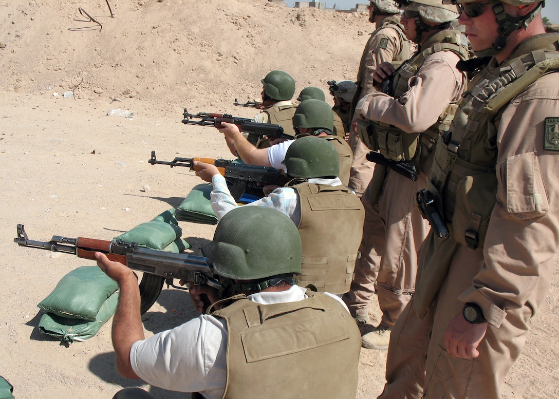 CAMP GANNON, HUSAYBAH, Iraq ? Marines with Viking Red Section, Mobile Assault Platoon, Regimental Combat Team 2, observe an Iraqi personal security detachment fire AK-47 rifles on a firing range here.  The Iraqis are training to be a personal security detachment for the judges in the area.