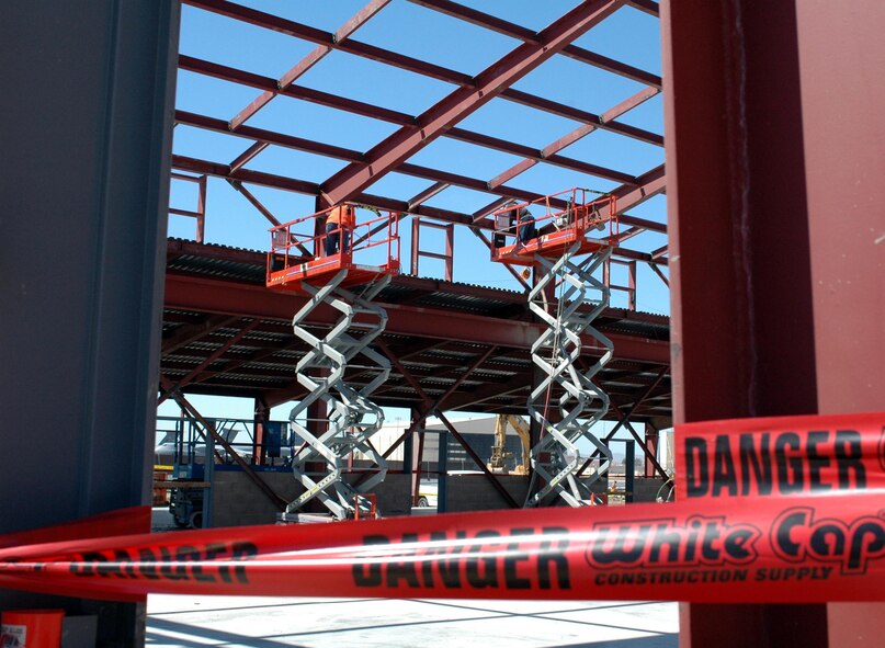 Red danger tape cordons off a portion of the working area at the Aerospace Ground Equipment building's future home as contractors weld steel before the building’s roof can be installed. In addition to the C-17 projects and the AGE building, Travis is also managing the construction of the 615th Contingency Response Wing’s $17.5 million warehouse. (U.S. Air Force photo/ Nick DeCicco)