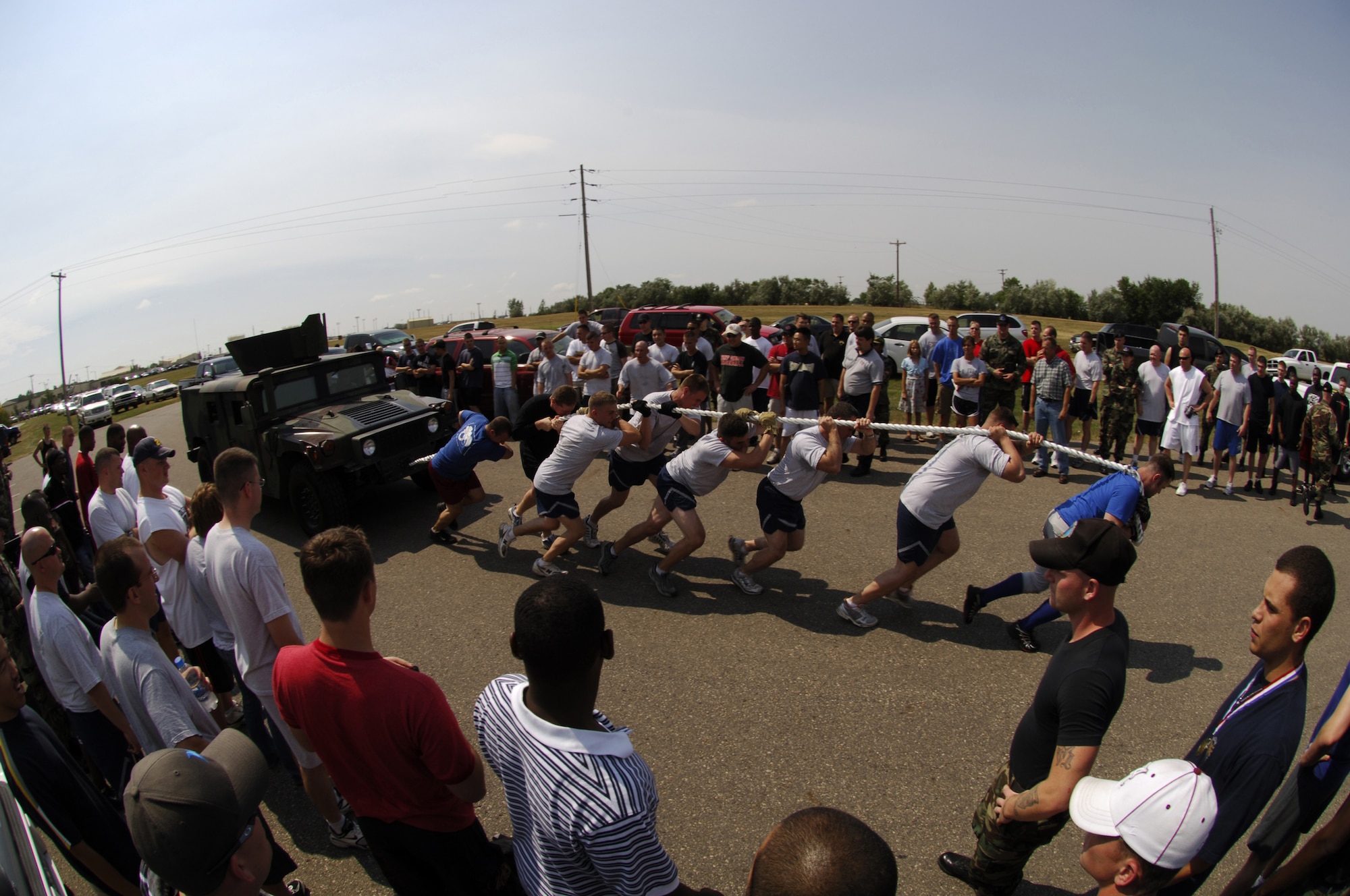MINOT AIR FORCE BASE, N.D. – Airmen from the 5th Security Forces Squadron  pool their strength to pull a 5,200-pound Humvee over the finish line during the base Sports Day Humvee-pull contest here Aug 10. Sports Day is an annual event set aside for units to participate as a group in various sporting activities. (U.S. Air Force photo by Senior Airman Stacy Moless)