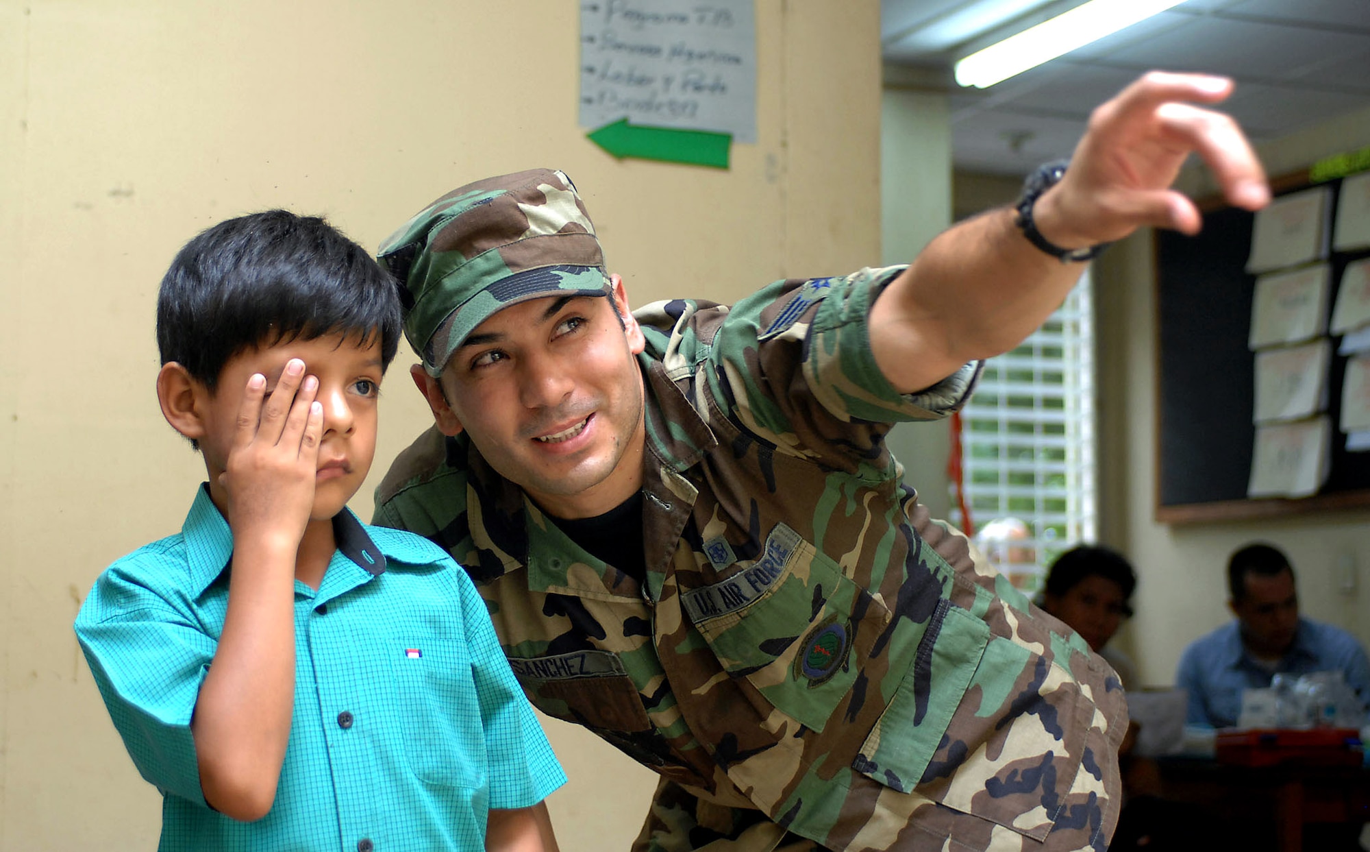 Airman Sebastian Sanchez assists a child during an eye examination July 21 at the 15 de Julio Health Care Center in Chinandega, Nicaragua. The USNS Comfort is on a four-month humanitarian deployment to Latin America and the Caribbean providing medical treatment to patients in a dozen countries. Airman Sanchez is a laboratory technician attached to the Military Sealift Command hospital ship USNS Comfort. (U.S. Navy photo/Petty Officer 2nd Class Steven King) 