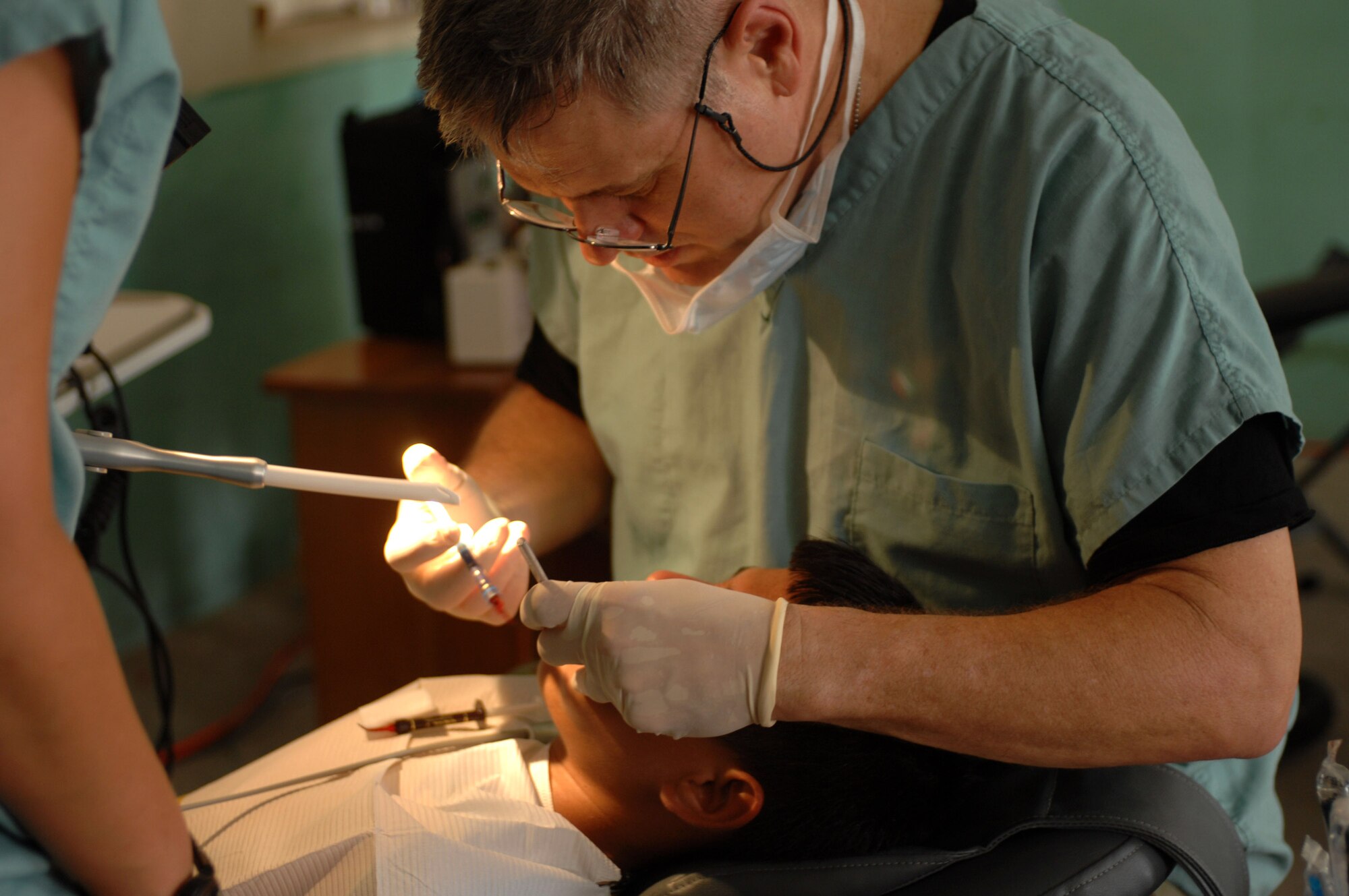 Lt. Col. (Dr.) Richard Tate provides dental care for a patient as Staff Sgt. Monica Christman helps Aug. 1 at the San Pablo Roman Catholic School in San Pablo, Belize. The U.S. Military Sealift Command hospital ship USNS Comfort is on a four-month humanitarian deployment to Latin America and the Caribbean providing medical treatment to approximately 85,000 patients in a dozen countries. While deployed, USNS Comfort is under operational control of U.S. Naval Forces Southern Command and tactical control of Destroyer Squadron 24. Colonel Tate is a deployed Air Force dentist and Sergeant Christman is a dental assistant. (U.S. Navy photo/Petty Officer 2nd Class Elizabeth Allen)
