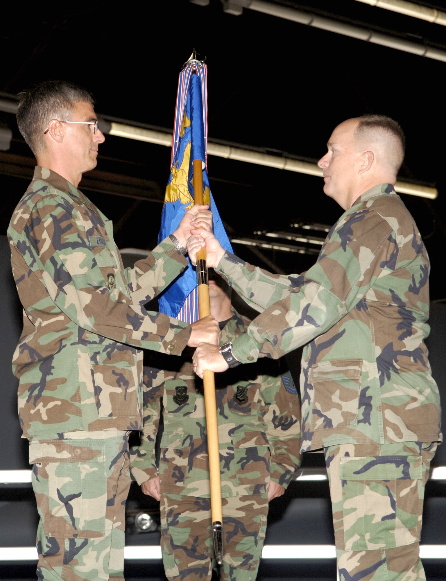 FAIRCHILD AIR FORCE BASE, Wash. – Maj. Robert Moore, the new 92nd Aircraft Maintenance Squadron commander, takes hold of the squadron flag as it is passed to him by Col. Robert Egbert, 92nd Maintenance Group commander, during a change-of command ceremony here Aug. 9. Major Moore assumed command from outgoing squadron commander Lt. Col. David Yockey. (U.S. Air Force photo / Senior Airman Chad Watkins)