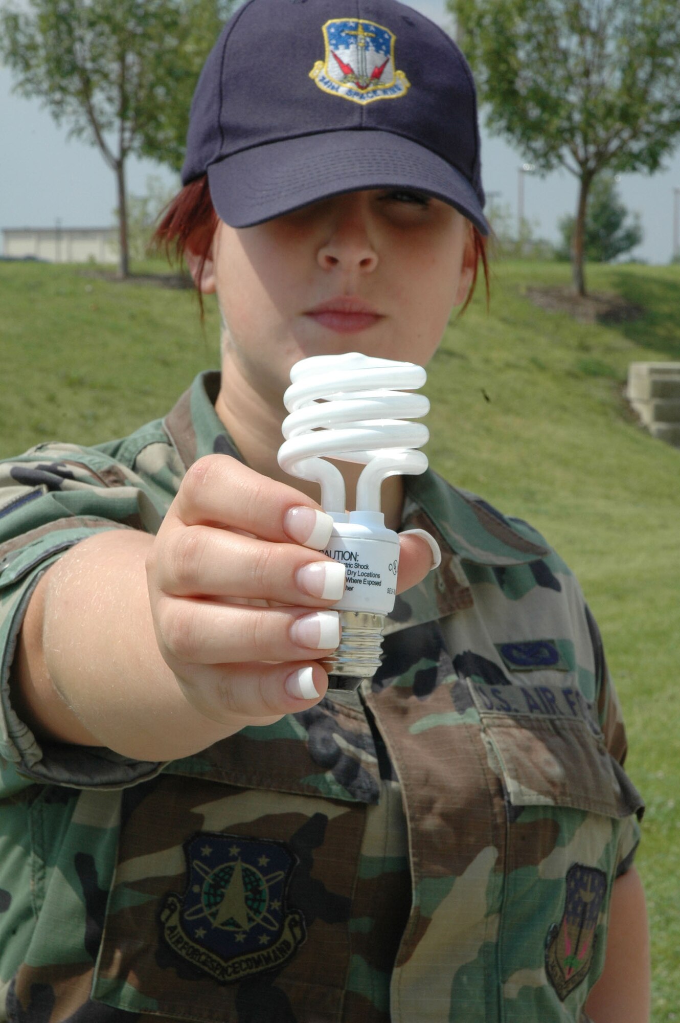 This 341st Space Wing Airman holds a compact fluorescent light bulb which uses 75 percent less energy than incandescent bulbs and lasts six to 10 times longer, according to www.energystar.gov. (U.S. Air Force photo/Senior Airman Eydie Sakura).