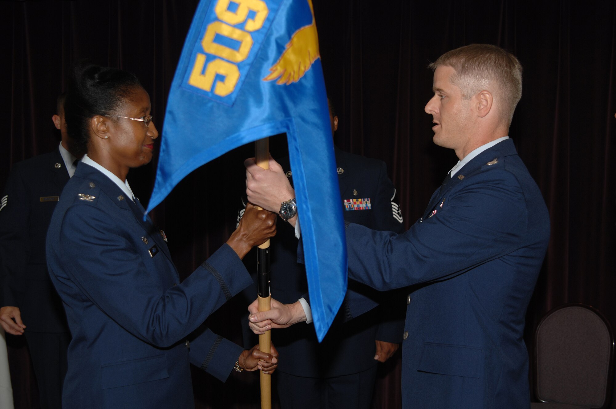 WHITEMAN AIR FORCE BASE, Mo. – Col. Gloria Twilley, 509th Medical Group commander, passes the guidon of the 509th Medical Support Squadron to Lt. Col. Matthew Escher during a change-of-command ceremony Aug. 13. Col. Escher was previously assigned to the 42d Medical Group at Maxwell Air Force Base, Ala.  Lt. Col. Jon Welch, the former 509th MDSS commander, moves on to Mountain Home AFB, Idaho, to become the 366th MDG deputy commander. (U.S. Air Force photo/Senior Airman Lauren Padden)
