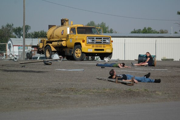 Three role-player victims sprawl out near a tanker, awaiting paramedics with injuries sustained in the simulated explosion during Operation Great Falls, a joint, off-base emergency response exercise that took place at the Montana Expo Park Aug. 9. (U.S. Air Force photo / Airman 1st Class Emerald Ralston)