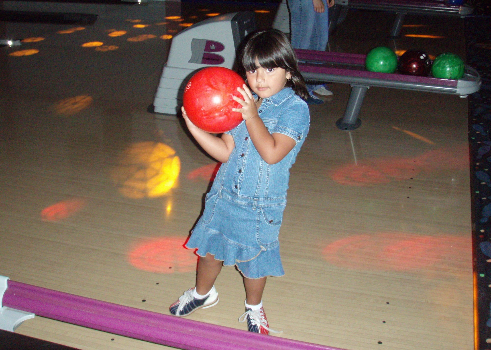 Graciela Dominguez, 4, daughter of SrA Carlos Dominguez, 39 Communications Squadron, financial clerk, shows off her bowling skills at the Magic Carpet Bowling Center during cosmic bowling on July 28. ( U. S. Air Force photo by Technical Sergeant Patrick R. Hyde)        