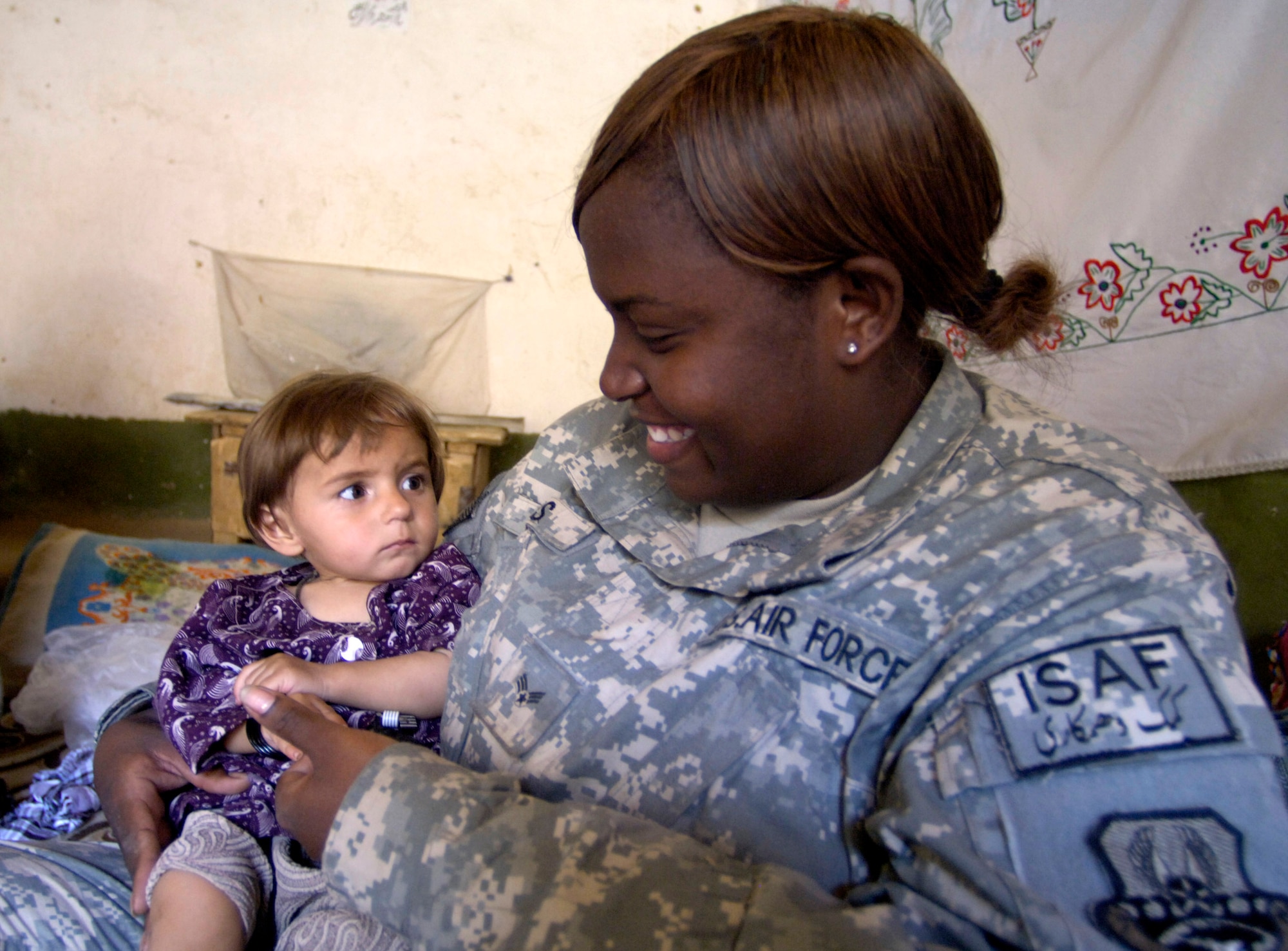 Panjshir Provincial Reconstruction Team member Senior Airman Alicia Woods makes friends with a village girl Aug. 7 in Roydara village in the Shutol district of Panjshir province, Afghanistan. Airman Woods is a medical technician deployed from Lackland Air Force Base, Texas. She and her fellow PRT members made an 11-mile round-trip trek over a mountain pass and into a river valley to provide medical care to Afghans living in Roydara. (U.S. Air Force photo/Staff Sgt. Julie Weckerlein)

