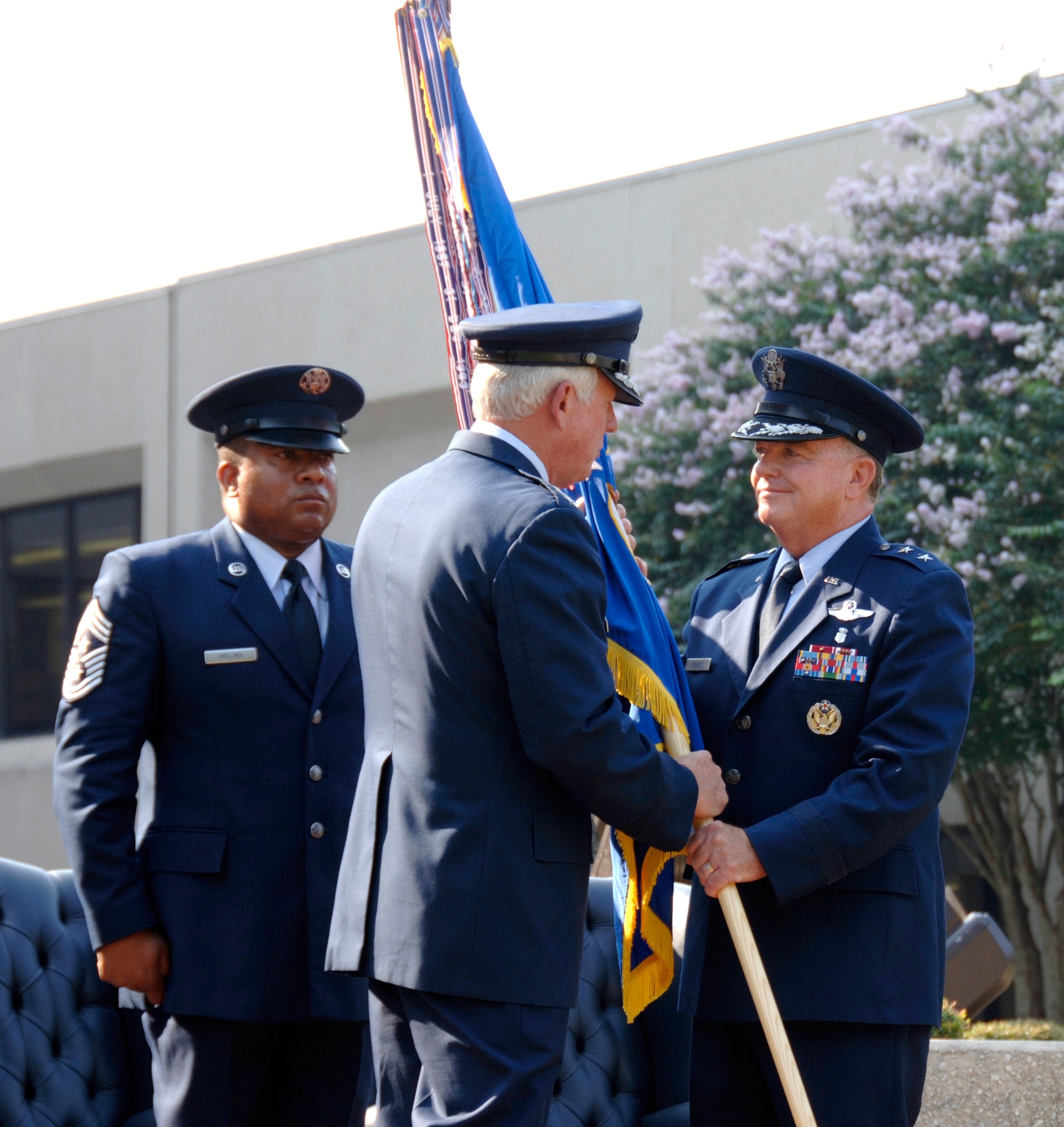 Maj. Gen. (Dr.) Thomas Travis (right) accepts the 59th Medical Wing guidon from Gen. William Looney III, Commander of Air Education and Training Command (center) while Chief Master Sgt. Richard Hollis, 59th MDW Command Chief, (left) looks on.  General Travis assumed command of the 59th MDW August 13. (U.S. Air Force photo by Master Sgt. Kimberly A. Yearyean-Siers)