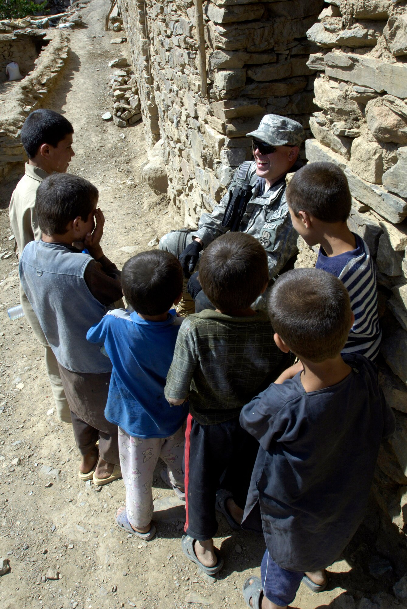 Tech. Sgt. Ralph Binion III shares a laugh with village boys Aug. 7 in Roydara village in the Shutol district of Panjshir province, Afghanistan. Sergeant Binion is a services craftsman deployed from Mountain Home Air Force Base, Idaho, and is a member of the Panjshir Provincial Reconstruction Team. He and his fellow PRT members made an 11-mile round-trip trek over a mountain pass and into a river valley to provide medical care to Afghans living in Roydara. (U.S. Air Force photo/Master Sgt. Jim Varhegyi)
