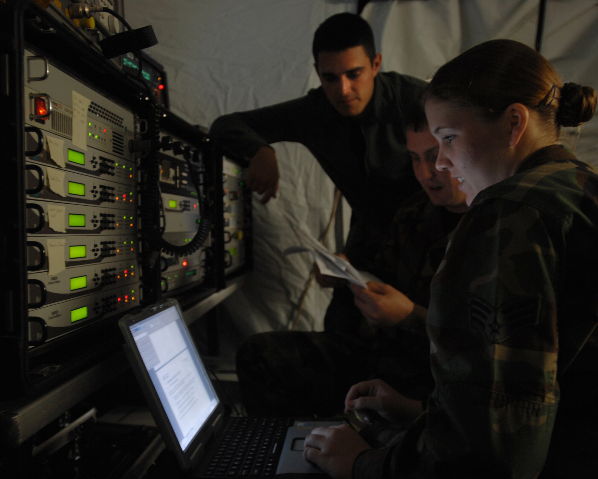(Left to right) Senior Airman Patrick Paez, Staff Sgt. Talmadge Beasley, and Senior Airman Ashley Scroggins, 1st Combat Communications Squadron, operate a satellite communications terminal in order to translate frequencies during exercise Healthy Star Aug. 9, 2007 at Ramstein Air Base, Germany. Healthy Star is a field training exercise that prepares combat communications Airmen for deployed situations. (U.S. Air Force photo/Airman 1st Class Kenny Holston)