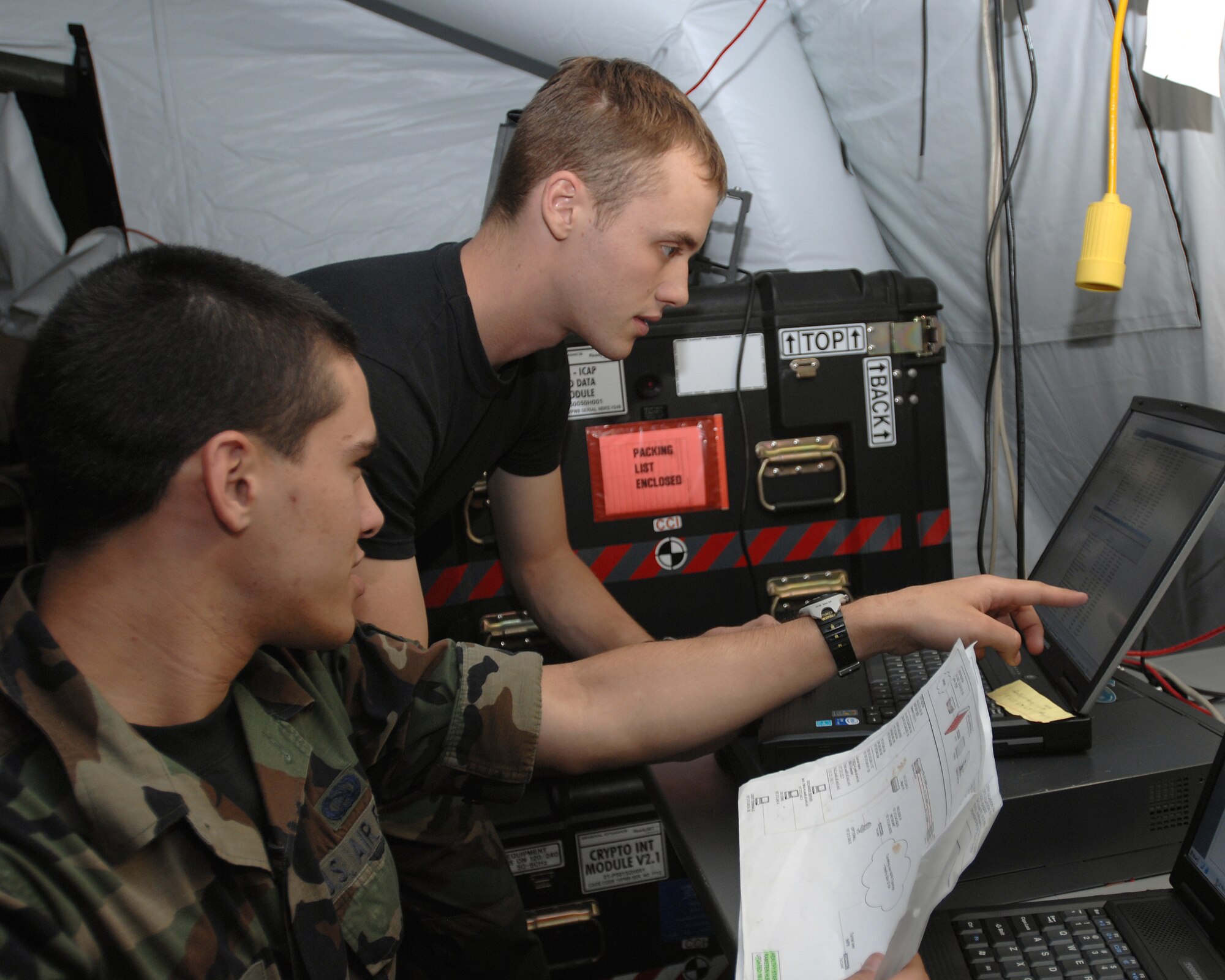 Airman 1st Class Nicholas Wittkamp (right) and Airman 1st Class Daniel Patton, 1st Combat Communications Squadron, install a hyperterminal on to a government computer during exercise Healthy Star Aug. 9, 2007 at Ramstein Air Base, Germany. Healthy Star is a field training exercise to prepare combat communications Airmen for deployed situations.  (U.S. Air Force photo/Airman 1st Class Kenny Holston)