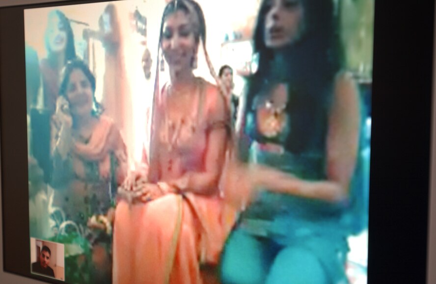 2nd Lt. Asim Khan, 18th Communications Squadron, bottom left of screen, asks the family members to sit his wife, Sadaf, in front of the camera after their wedding ceremony over the internet, Aug. 4. Lieutenant Khan officially married Sadaf while she was in Pakistan and he was here.  They are planning to have a formal wedding in December.
(U.S. Air Force photo/Staff Sgt. Reynaldo Ramon)
