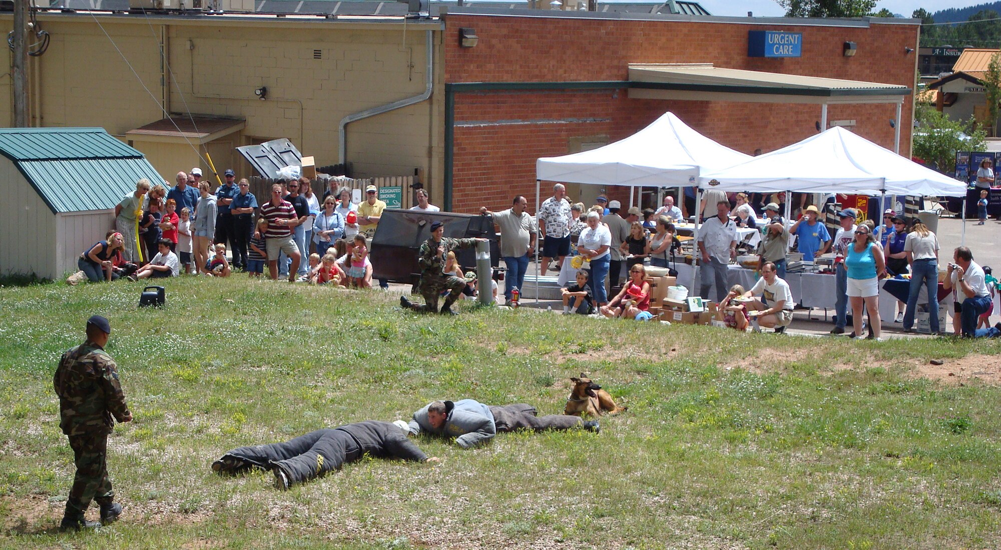 Peterson Airmen gave a military working dog demonstration Aug. 4 in Woodland Park, Colo. Here, Tech. Sgt. Jesse Frank, 21st Security Forces Squadron, and his dog Atak, showed the crowd how they detain a suspect. Sergeant Frank also explained the importance of the working dogs while deployed to Afghanistan or Iraq. "If we could bring a dog (on patrol) with us, we did," Sergeant Frank said. "We use them for just about everything over there, searching vehicles, searching stuff coming onto the base, (including) mail. Unfortunately, we never have enough dogs." The demonstration was part of the 25th anniversary of Langstaff-Brown Urgent Care Center in Woodland Park. (Courtesy photo)