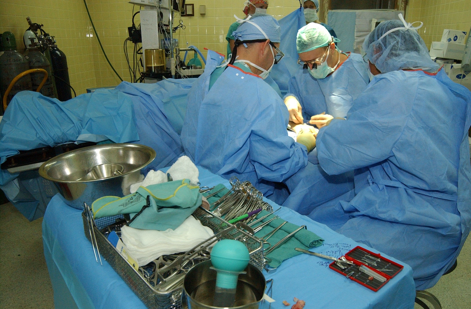 Army orthopedic surgeons Lt. Col. Chris Wilson (left) and Maj. Pat Pollock (center) work to repair a patient's congenital hand deformity as scrub nurse Leo Vasquez assists.  The medical team is visiting Honduras as part of a hand-surgery Medical Readiness Exercise, commonly called a MEDRETE, Aug. 13-24.  Medical personnel from military installations across the United States joined with personnel from Soto Cano Air Base in Honduras to conduct the MEDRETE.  The MEDRETE team anticipates treating nearly 100 patients by the end of the exercise.  Air Force photo by Tech. Sgt. Sonny Cohrs.