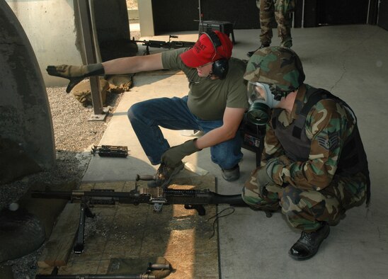 Mr. Ryan Shoemaker points out a set of targets to Staff Sgt. Clifford Kinsman to aim at during an M-240B machine gun course at Malmstrom Air Force Base's Combat Arms Training and Maintenance facility Aug. 13, 2007.  (U.S. Air Force photo by Airman 1st Class Dillon White)          