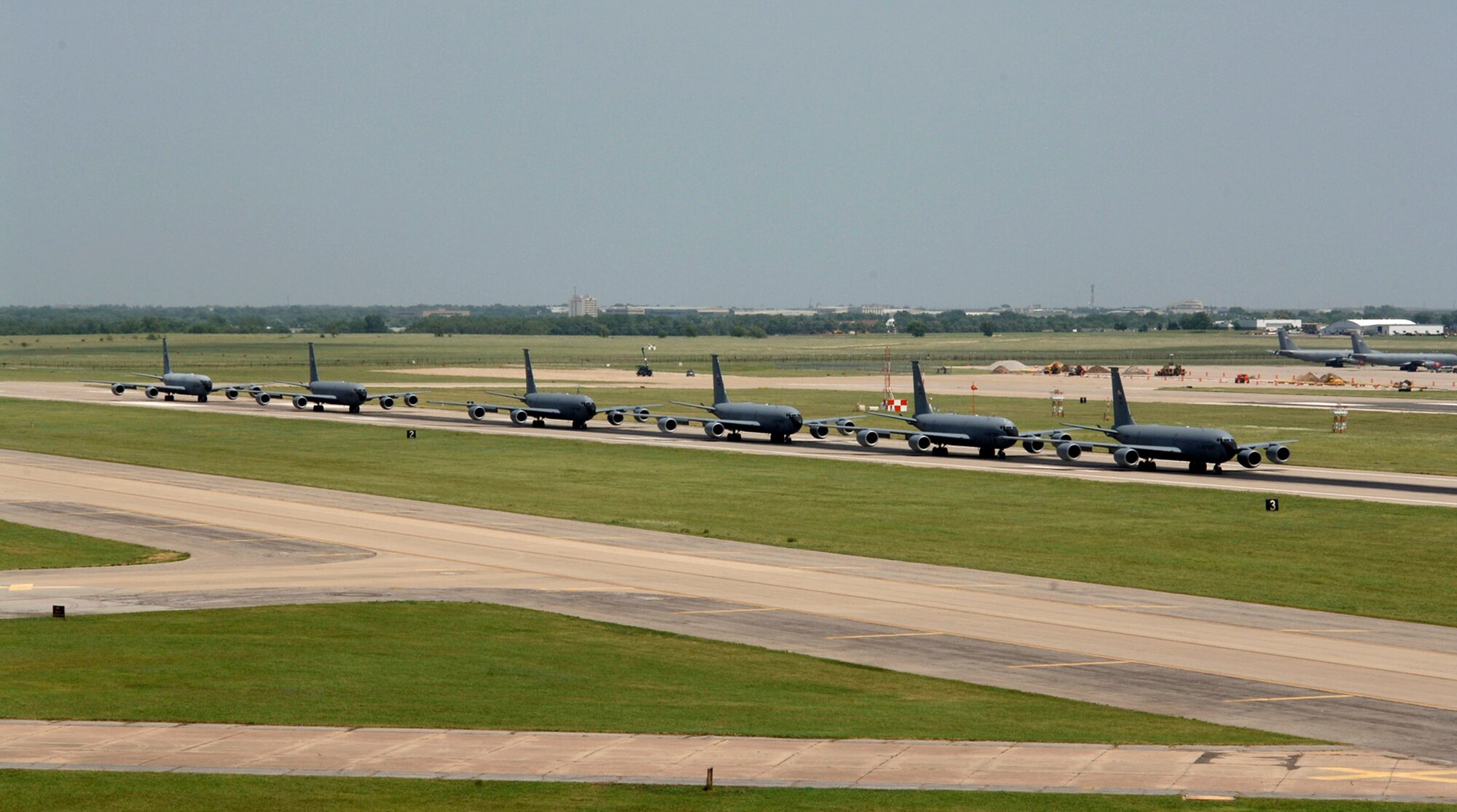 Six KC-135 Stratotankers demonstrate the elephant walk formation as they taxi down a runway right behind each other during a generation exercise Aug. 5 at McConnell Air Force Base, Kan. The exercise showcased McConnell AFB aircrews' capability to prepare a flight and take off within minutes of being notified of a mission. (U.S. Air Force photo/Tech. Sgt. Chyrece Campbell)

