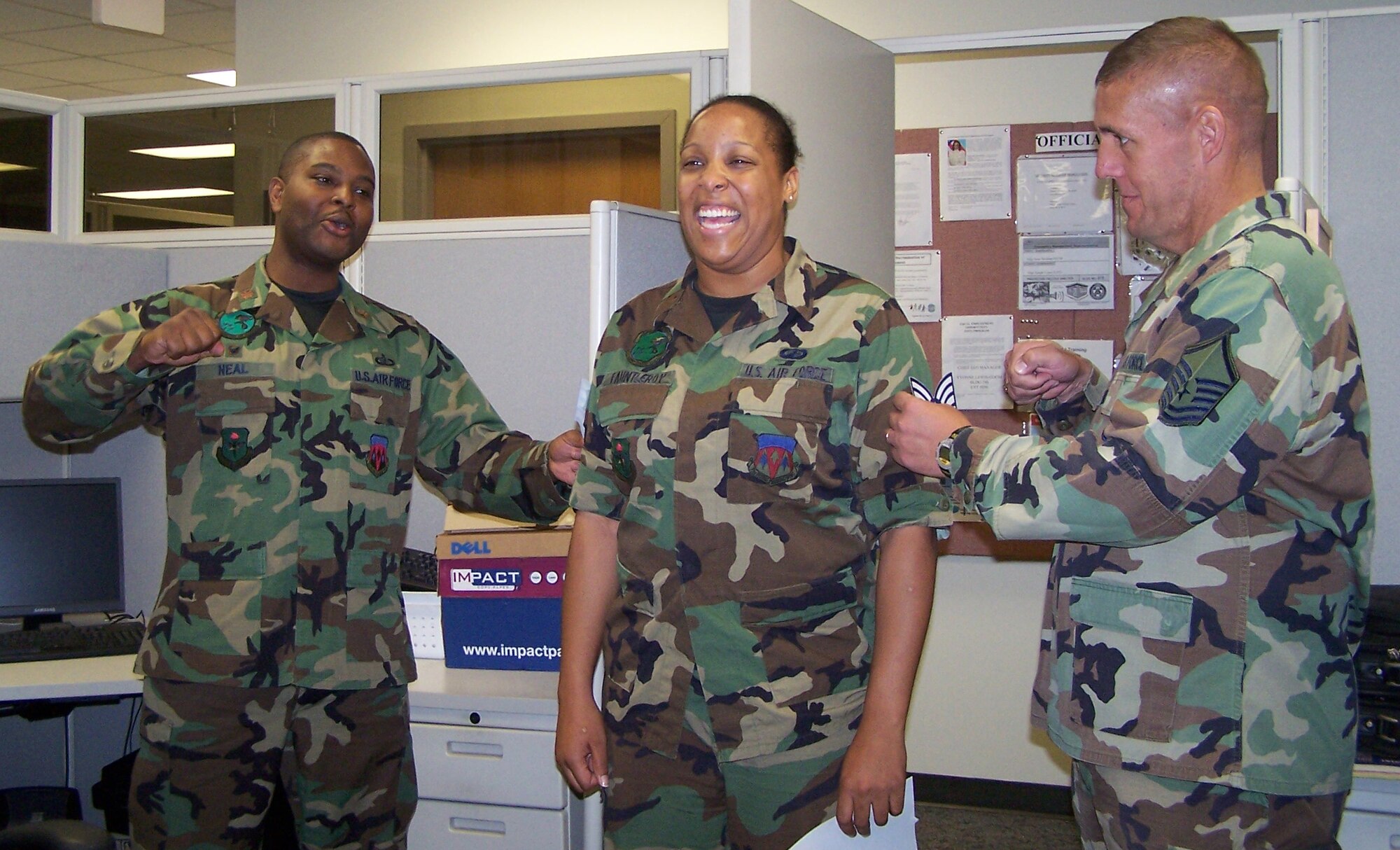 Maj. Monroe Neal Jr. and Master Sgt. John Ward, 71st Comptroller Squadron, “tack” Senior Airman Latasha Fauntleroy’s paper staff sergeant stripes on Wednesday after notifying her of her promotion.  Fifteen Vance senior airmen were part of the 15,130 Air Force-wide recently selected for promotion to staff sergeant. (U.S. Air Force photo by Capt. Tony Wickman)