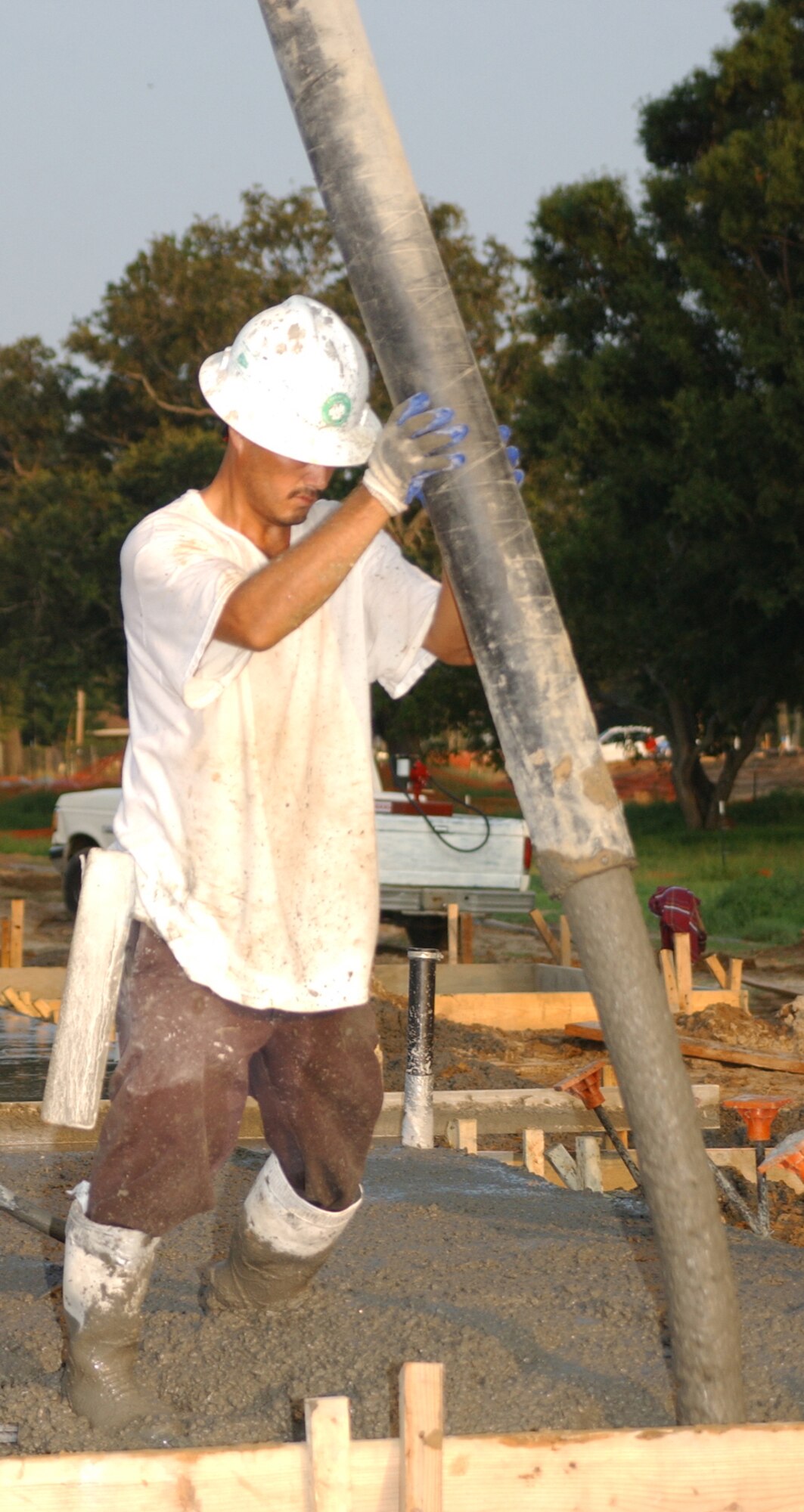 Tobias Acosta controls the flow of concrete for a slab in Thrower Park Aug. 8.  (U.S. Air Force photo by Kemberly Groue)