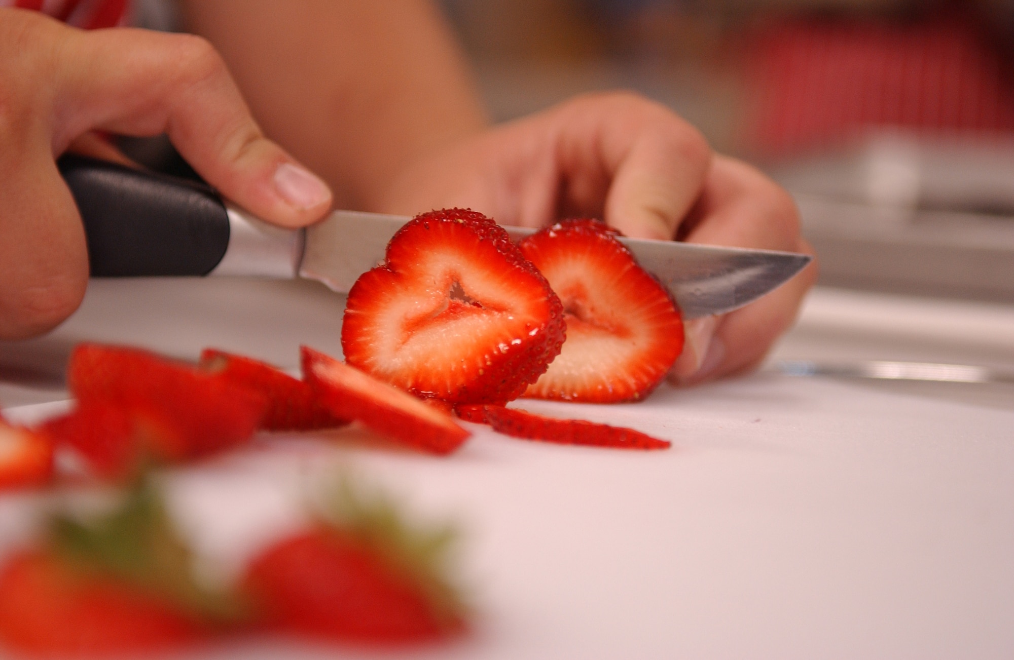 EIELSON AIR FORCE BASE, Alaska -- Kaleb Albert, son of Heather and Staff Sgt. Matthew Albert, 354th Contracting Squadron, slices strawberries for his pastry desert August 14 at the Youth Center. The Youth Center is conducting a six-week cooking program for children aged 9-12 to teach them the importance of eating healthy and experimenting with different tastes. (U.S. Air Force Photo by Airman 1st Class Jonathan Snyder)(Released)