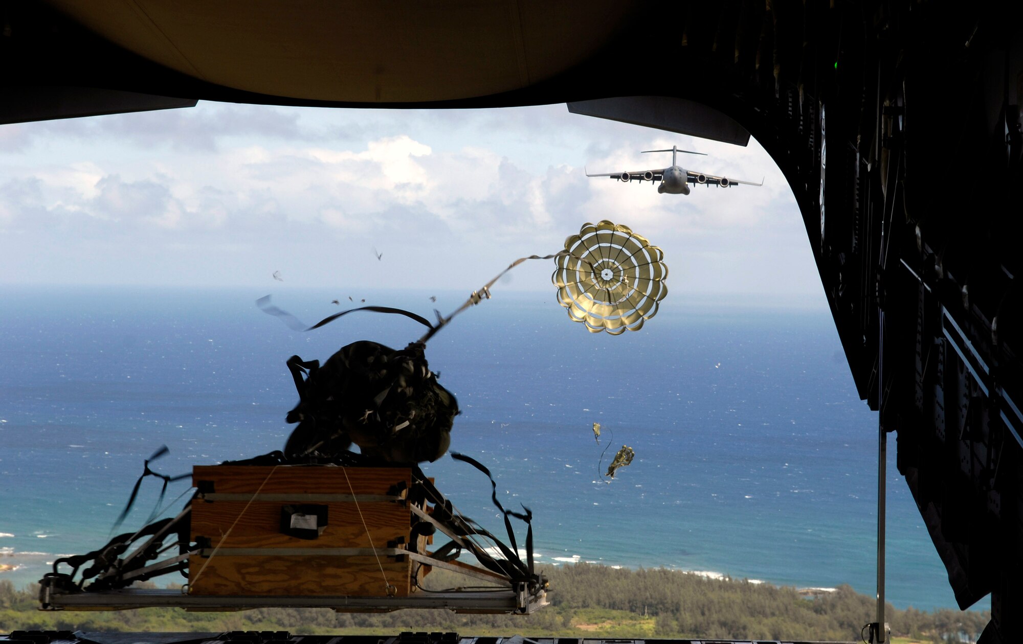 A practice pallet is released from the back of a C-17 Globemaster III during an airdrop training mission Aug. 13 over the Pacific. C-17s from the 535th Airlift Squadron of Hickam Air Force Base, Hawaii, took part in a four-ship, multi-element airdrop training mission to maintain currency and proficiency. (U.S. Air Force photo/Tech. Sgt. Shane A. Cuomo) 
