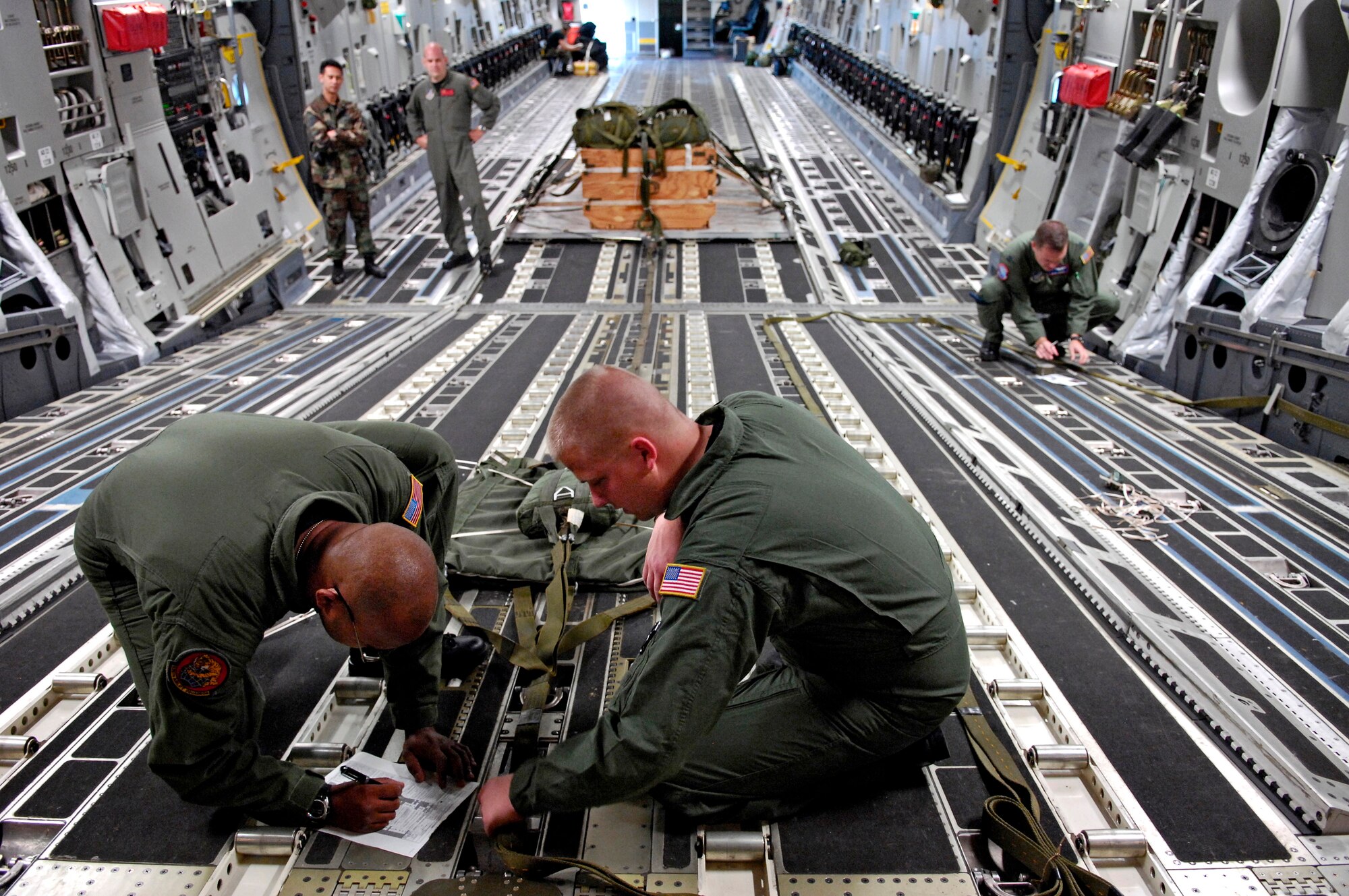 Staff Sgt. Ike Murray goes over a joint airdrop inspection checklist with Senior Airman Todd Tichawa for an upcoming C-17 Globemaster III four-ship, airdrop training mission Aug. 13 at Hickam Air Force Base, Hawaii. The Airmen are from the 535th Airlift Squadron. (U.S. Air Force photo/Tech. Sgt. Shane A. Cuomo) 
