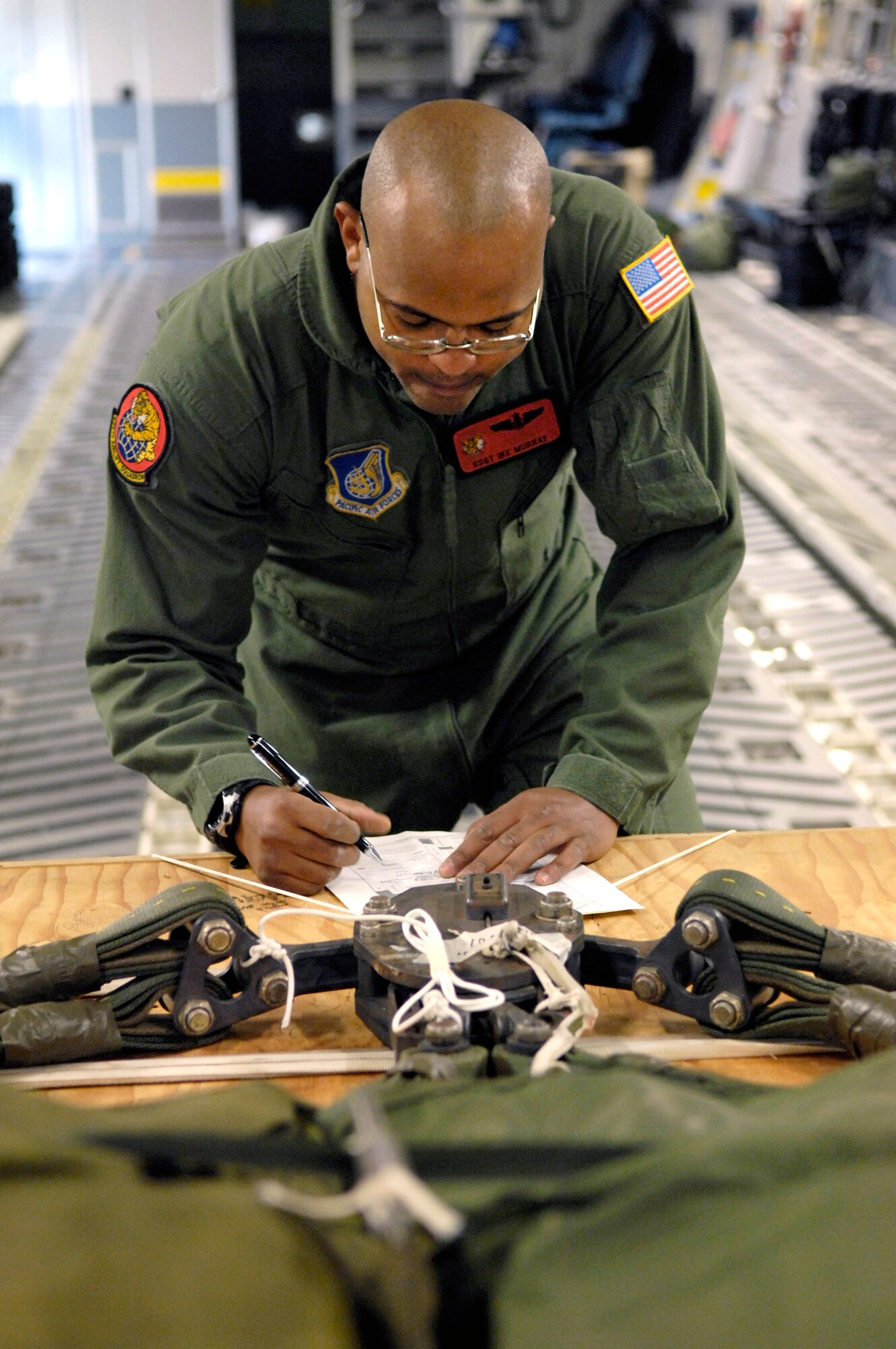 Staff Sgt. Ike Murray goes over a joint airdrop inspection checklist Aug. 13 at Hickam Air Force Base, Hawaii. Sergeant Murray, a loadmaster with the 535th Airlift Squadron, is inspecting the parachute rigging on a C-17 Globemaster III for a four-ship, airdrop training mission. (U.S. Air Force photo/Tech. Sgt. Shane A. Cuomo) 
