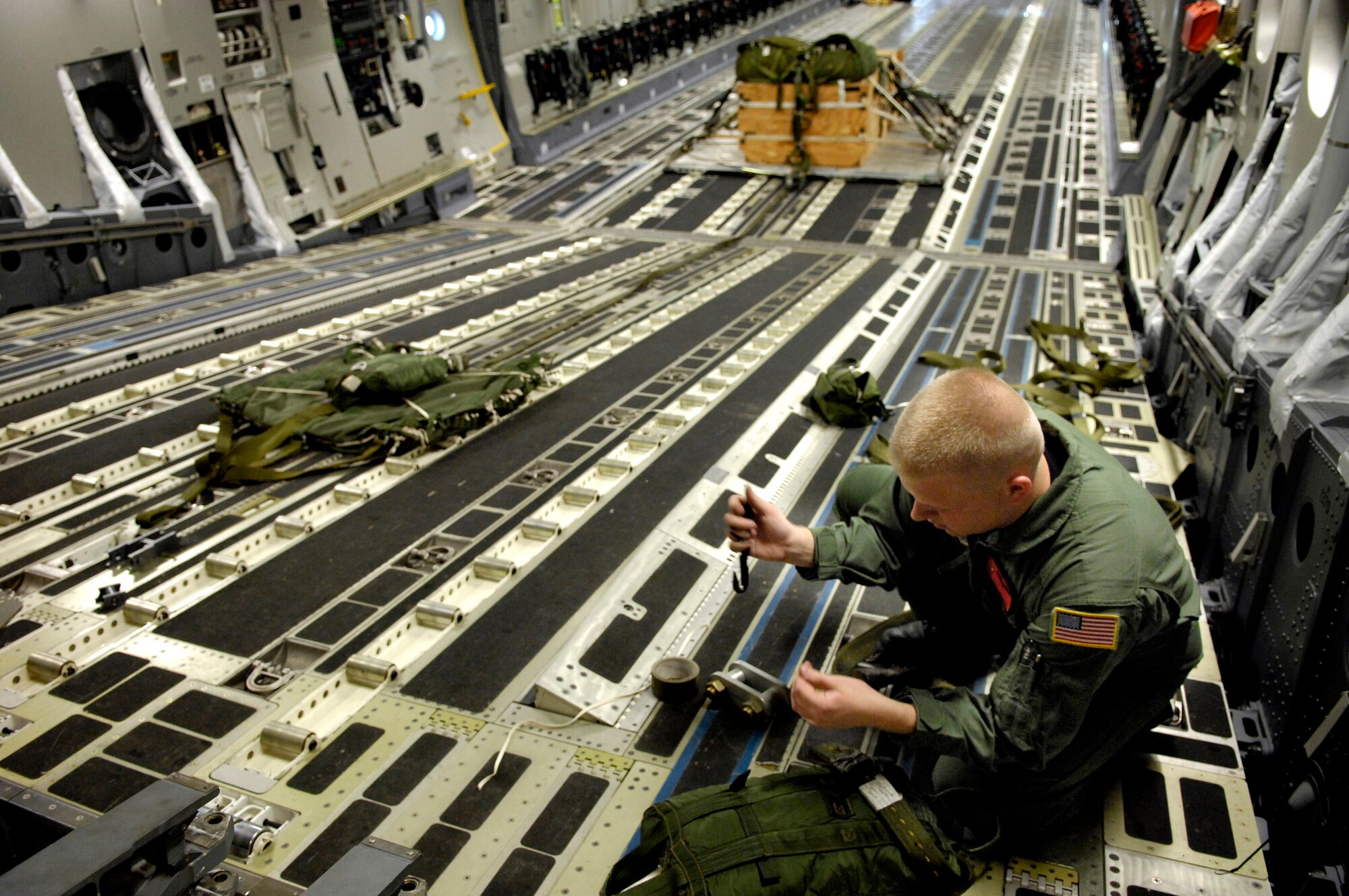 Senior Airman Todd Tichawa prepares the rigging for a parachute on his C-17 Globemaster III Aug. 13 at Hickam Air Force Base, Hawaii. Airman Tichawa, a loadmaster from the 535th Airlift Squadron, is taking part in a four-ship, multi-element airdrop training mission to maintain currency and proficiency. (U.S. Air Force photo/Tech. Sgt. Shane A. Cuomo) 
