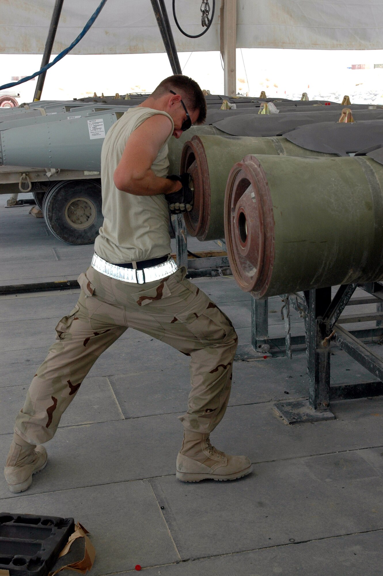 Senior Airman John Neufield torques a fuze-retaining ring on a bomb.  Airman Neufeld is with the 379th Expeditionary Maintenance Squadron's ammo flight at a deployed location in Southwest Asia.  (U.S. Air Force photo/Capt. Teresa Sullivan) 