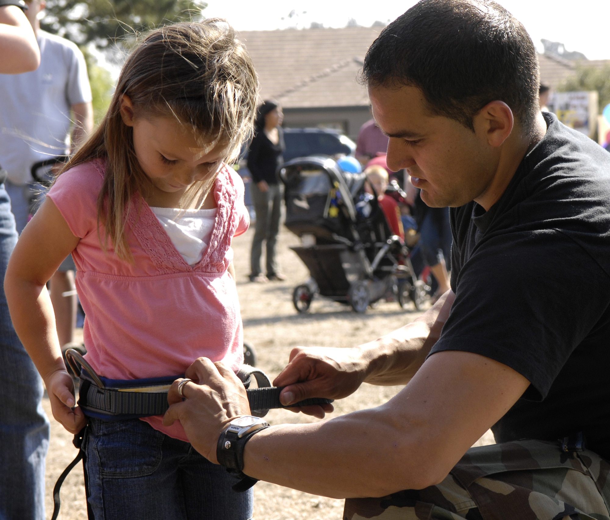 VANDENBERG AIR FORCE BASE, Calif. -- Alex Conway, a 6 year old resident of Vandenberg, gets strapped in by Staff Sgt. Mike Guerrero, 30th Security Forces Squadron, before climbing the rock wall during the National Night Out on Aug.10.  National Night Out is an event designed to increase children's awareness of safety. (U.S. Air Force photo/Airman Jonathan Olds)