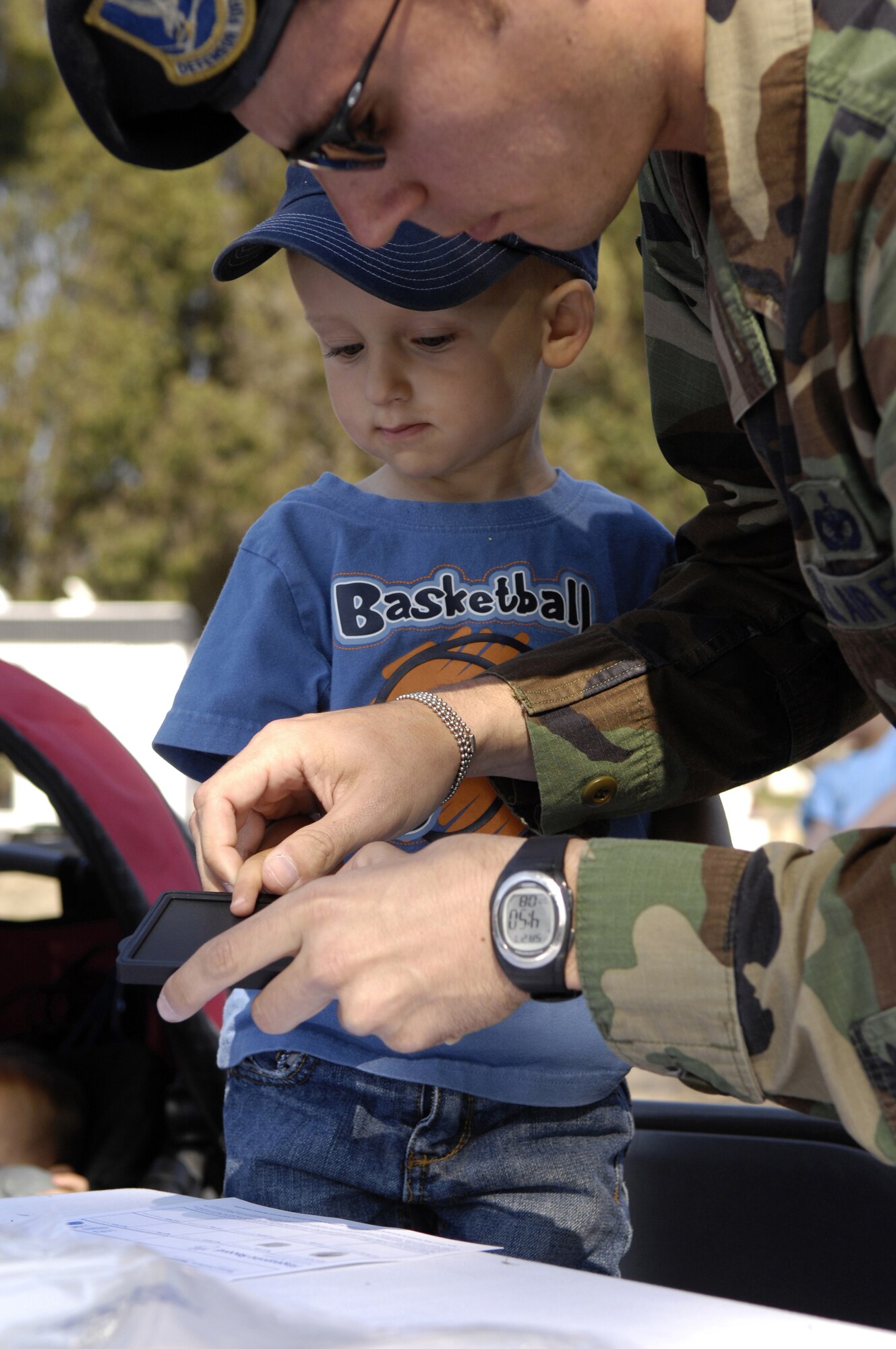 VANDENBERG AIR FORCE BASE, Calif. -- Tyler McDaniel, a 2-year-old resident of Vandenberg, gets finger printed by Staff Sgt.Trinity Brown, 30th Security Forces Squadron, during the National Night Out on Aug.10.  National Night Out is an event designed to increase children's awareness of safety. (U.S. Air Force photo/Airman Jonathan Olds)