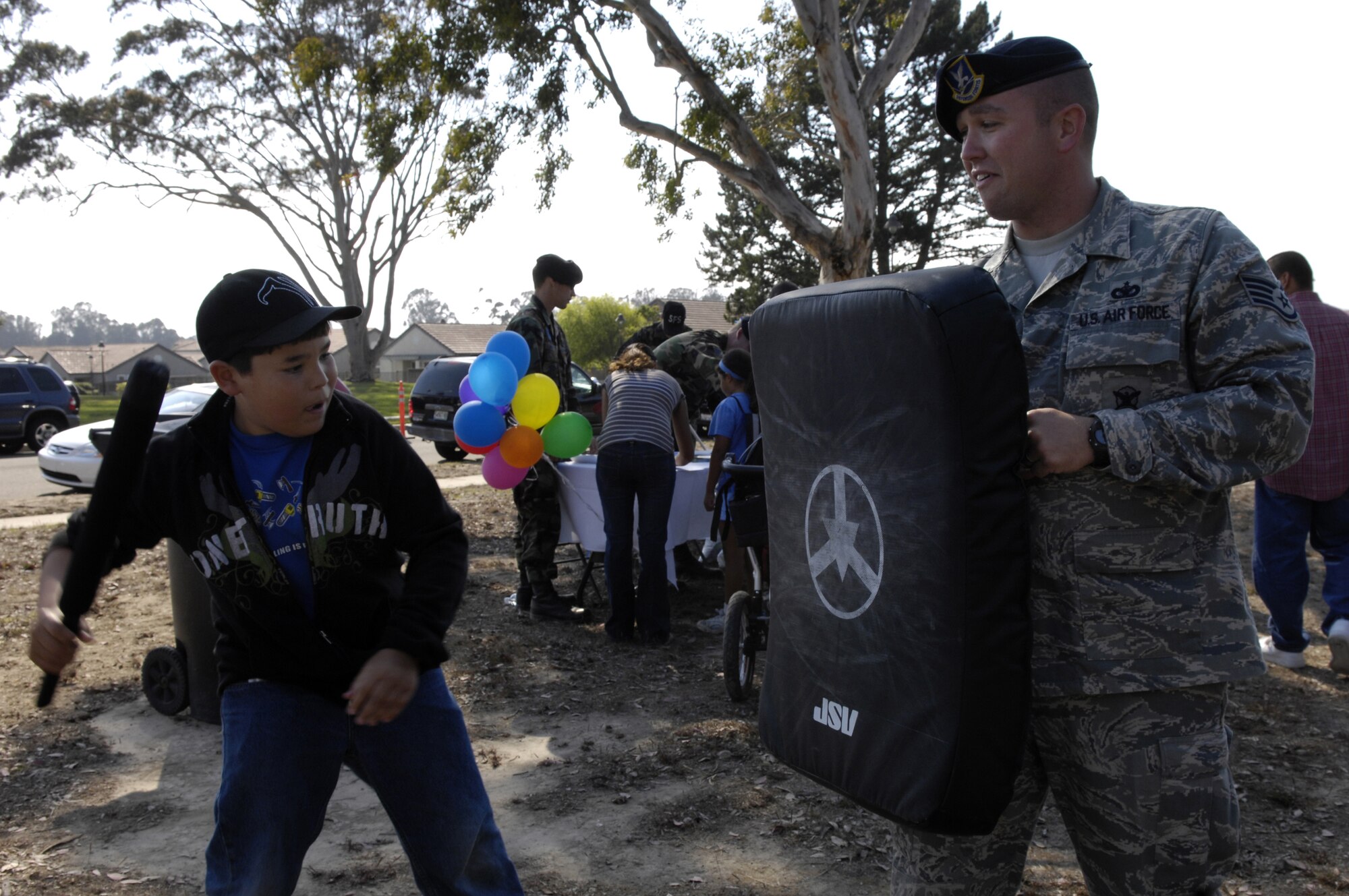 VANDENBERG AIR FORCE BASE, Calif. -- Caleb Leduc, a 10-year-old resident of Vandenberg, swings at a pad held by Staff Sgt. Michael Myers, 30th Security Forces Squadron, during the National Night Out on Aug.10.  National Night Out is an event designed to increase children's awareness of safety. (U.S. Air Force photo/Airman Jonathan Olds)