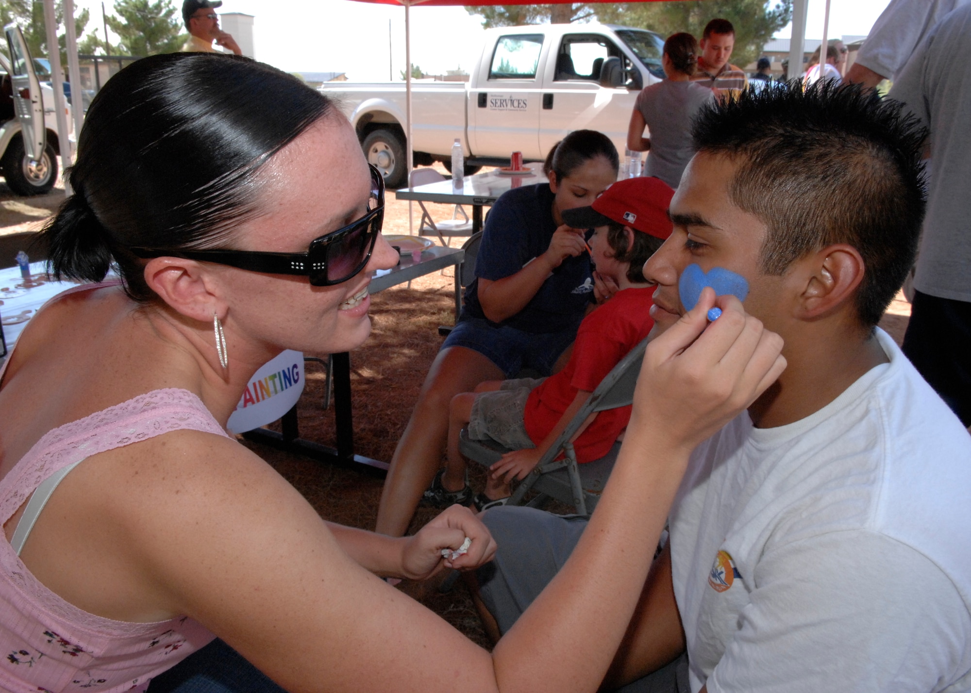 Airman 1st Class Shealyn Wenzel, 49th Materiel Maintenance Support Squadron, face paints at the Holloman Warrior Cookout and Concert event at Holloman Aug. 10. The event was in honor of upcoming deploying Airmen. (U.S. Air Force photo by Airman 1st Class Rachel Kocin)