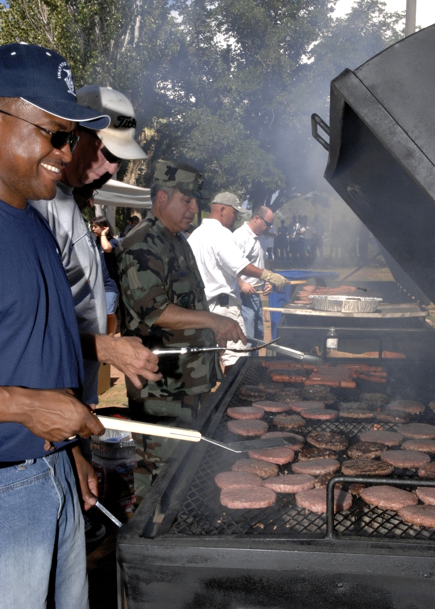 Volunteers cook on the grill at the Holloman Warrior Cookout and Concert event at Holloman Aug. 10. The event was in honor of upcoming deploying Airmen. (U.S. Air Force photo by Airman 1st Class Rachel Kocin)