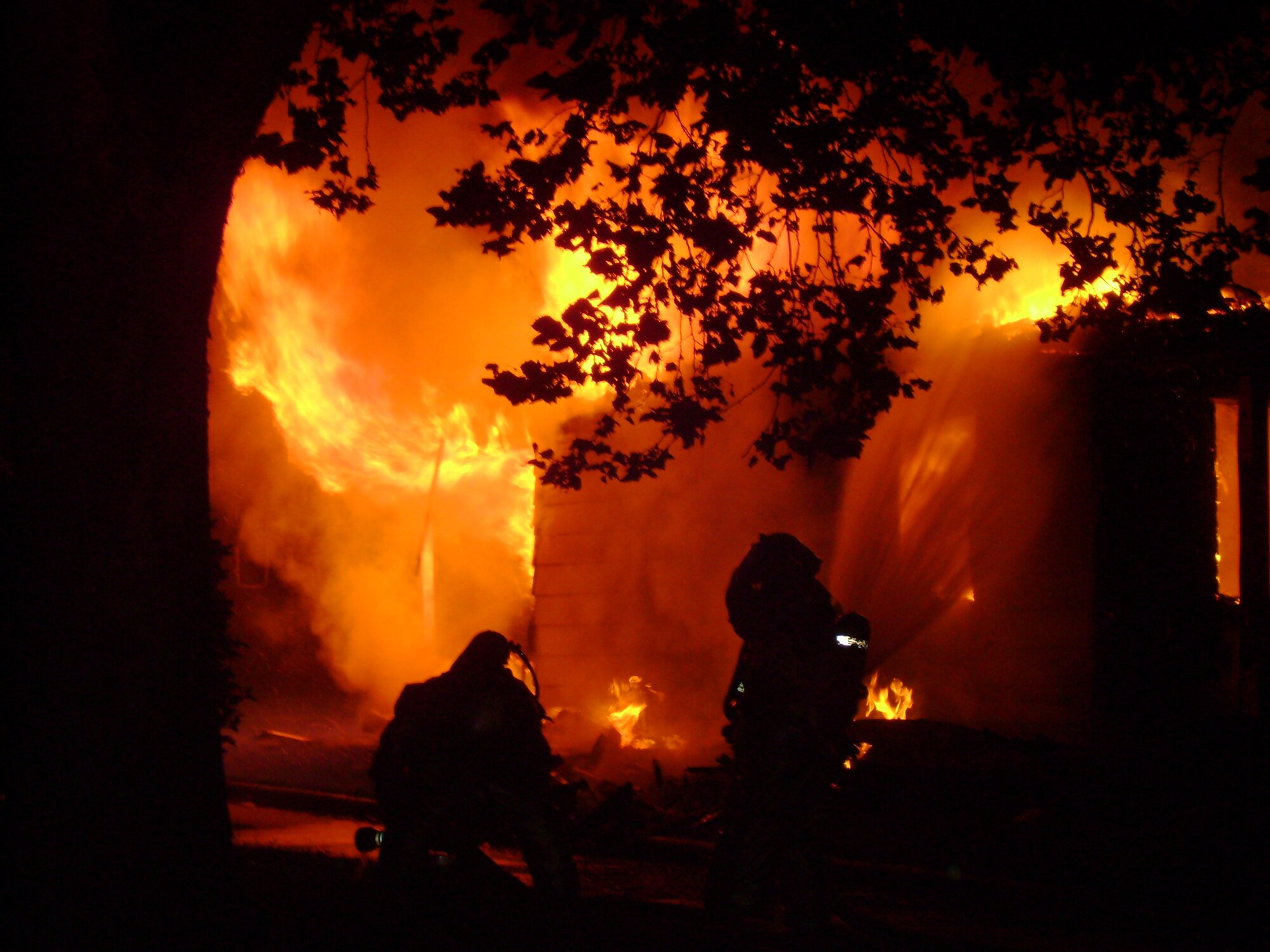 Firefighters from both the 82nd Civil Engineer Squadron and the Wichita Falls Fire Department labor to extinguish the flames at 103 Childress Street in Wherry Housing Aug. 14. No one was inside the house at the time of the fire, and none of the responders were injured. (U.S. Air Force photo)                               