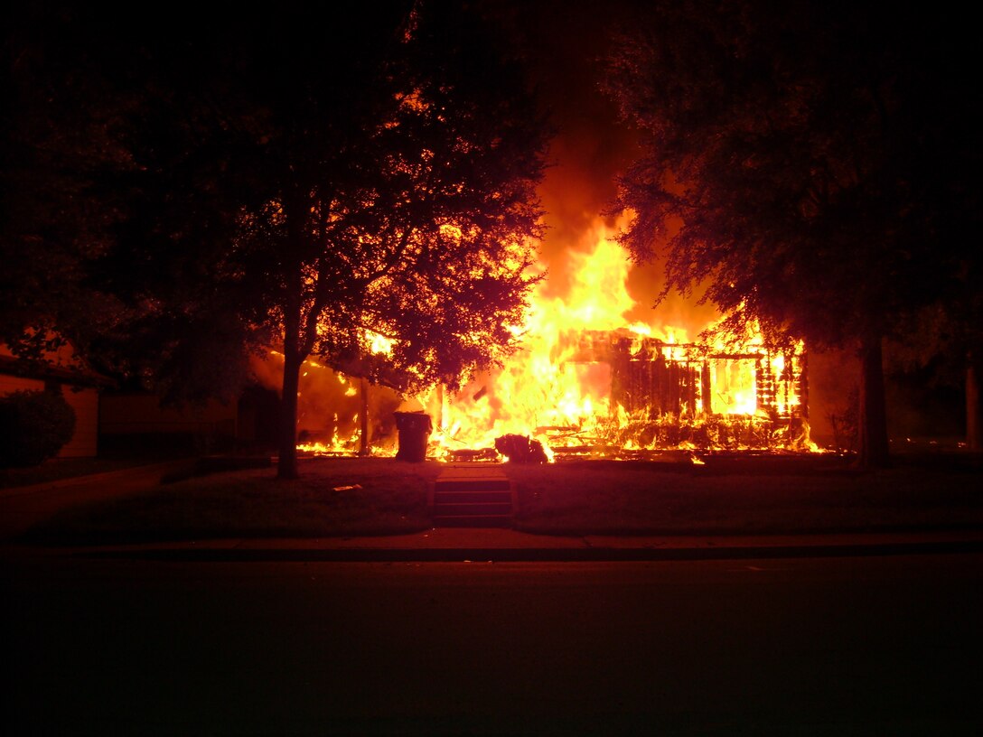 A fire at 103 Childress Street completely destroyed the Wherry Housing unit Aug. 14.  The house was vacated only hours before, and none of the responders were injured while dousing the flames.  (U.S. Air Force photo)                    