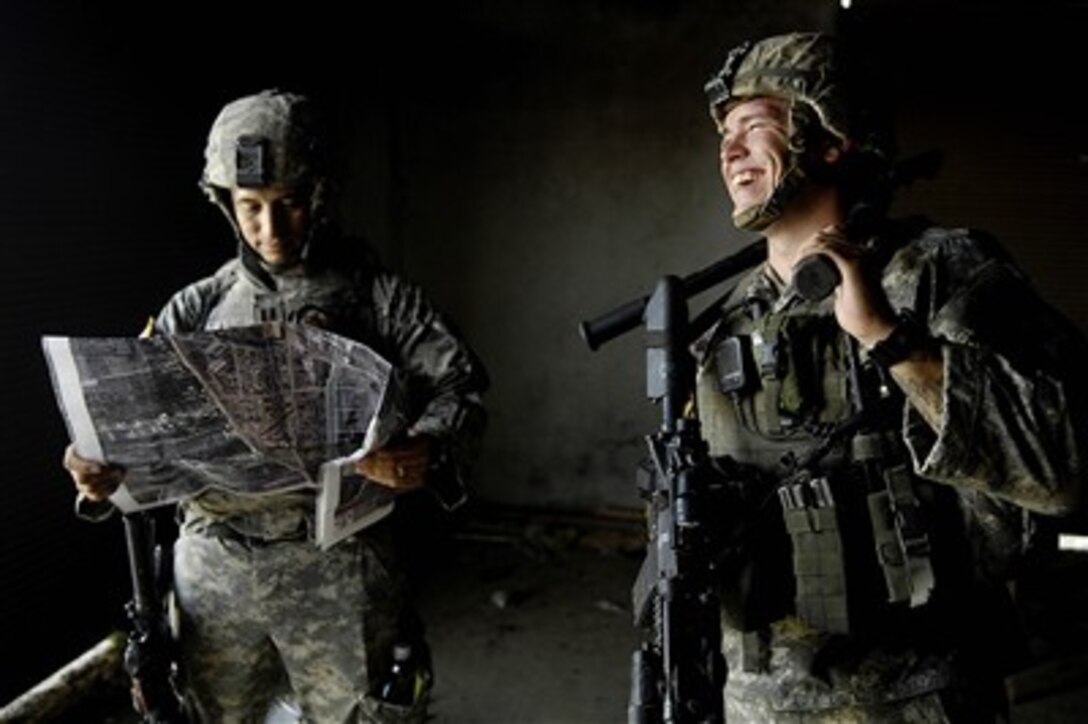 Two U.S. Army soldiers of Charlie Company, 1st Battalion, 23rd Infantry Regiment, 3rd Stryker Brigade Combat Team, 2nd Infantry Division share a lighter moment as they discuss operations in Baqubah, Iraq, on Aug. 10, 2007.  The soldiers, along with Iraqi army soldiers of 1st Company, 2nd Battalion, 2nd Brigade, conducted operations in Baqubah to defeat insurgents and locate weapons caches.  