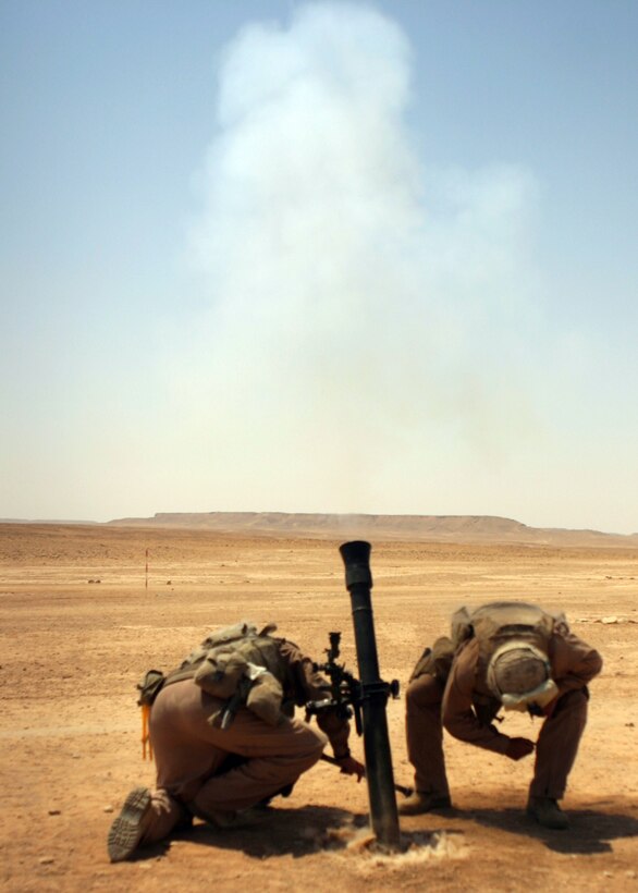 CAMP AL QA?IM, Iraq ? Smoke bellows from an 81mm mortar tube while Marines with Mobile Assault Platoon 3, Weapons Company, Task Force 1st Battalion, 4th Marine Regiment, Regimental Combat Team 2, cover themselves for protection during a Fire Support Coordination Exercise here.  Many Marines were new to forward scout observing and firing from a mortar tube.