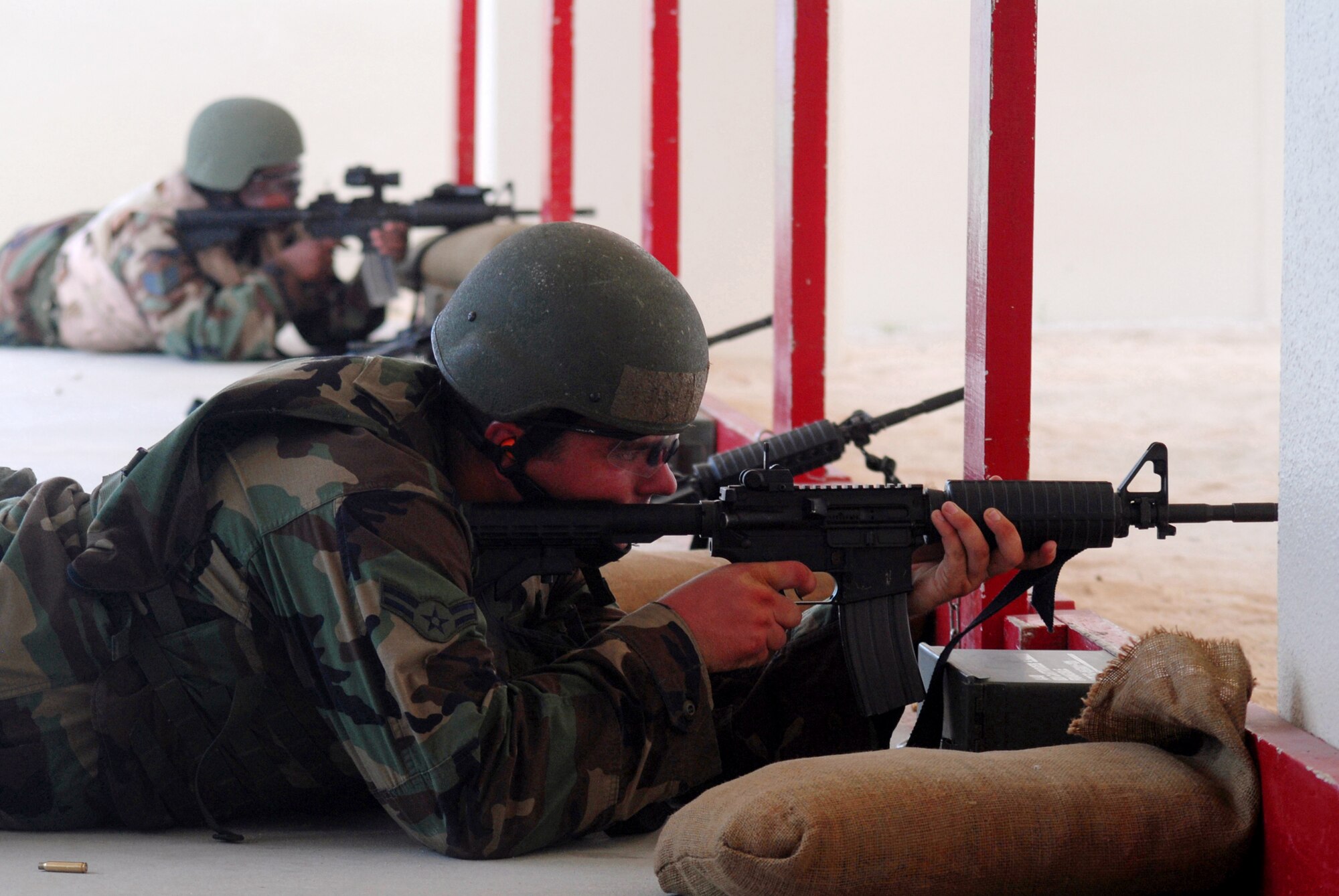 Airman 1st Class Daniel Wallace (front) and Staff Sgt. Shanika Lane fire at targets during the M4 Tactical Qualification Course at Kadena Air Base, Japan, Aug. 7, 2007. The course ensures every security forces member stays qualified with the M4 rifle.  Both are assigned to the 18th Security Forces Squadron.  (U.S. Air Force photo/Senior Airman Darnell T. Cannady)