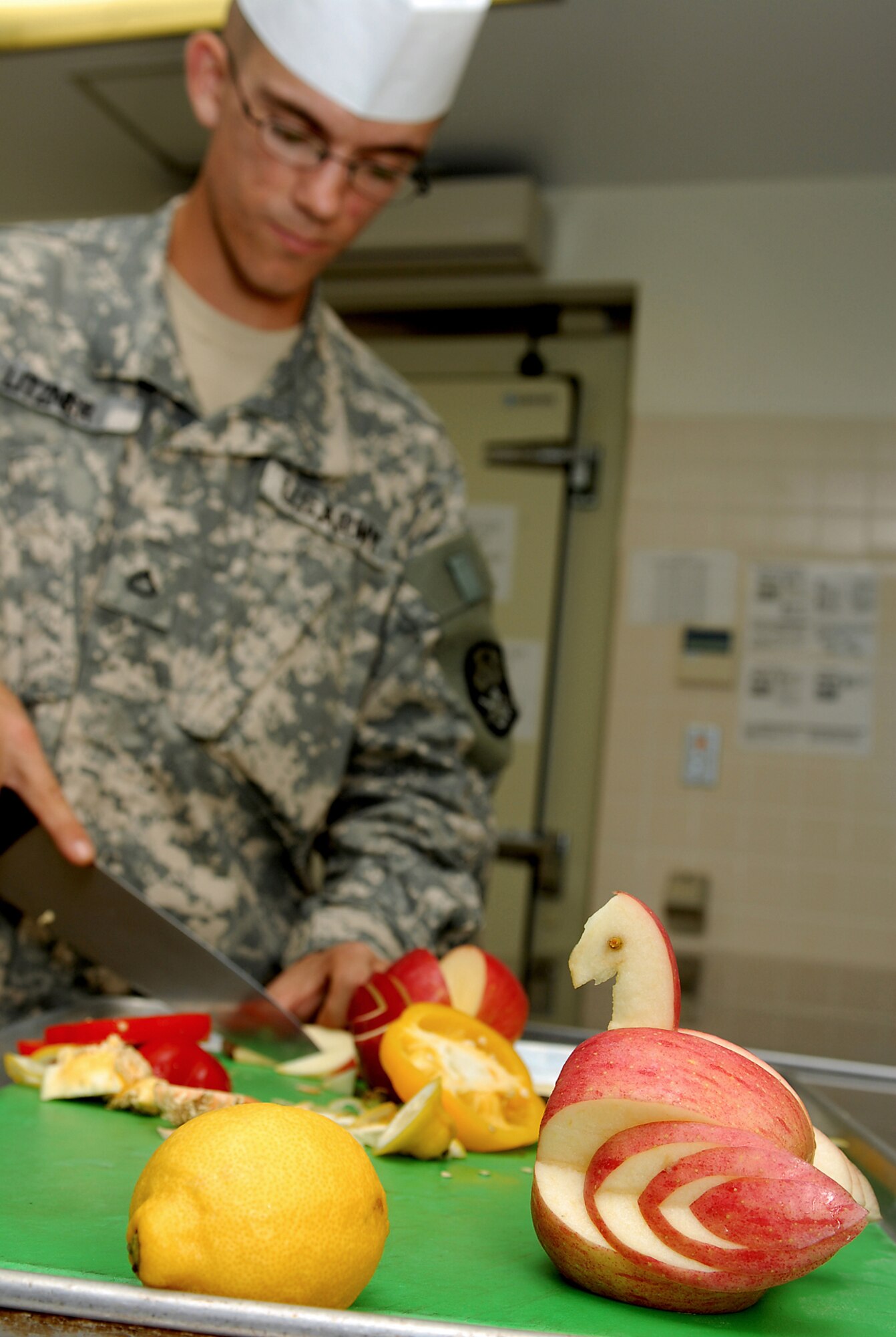 Army Private 1st Class Christopher Litzner skillfully carves a swan from an apple to be used as a decoration for the food lines of  Marshall Dining Facility at Kadena Air Base, Japan, Aug. 15, 2007.  Making garnishes help the cooks maintain their showmanship and turns the feel of the dining facility into that of a nice restaurant.  The Marshall Dining Facility serves three meals to more than 1,000 U.S. military military members daily.  Private Litzner is from the 1-1 Air Defense Artillery Battalion and works side-by-side with 18th Services Squadron Airmen.  
(U.S. Air Force photo/Airman 1st Class Kelly Timney)