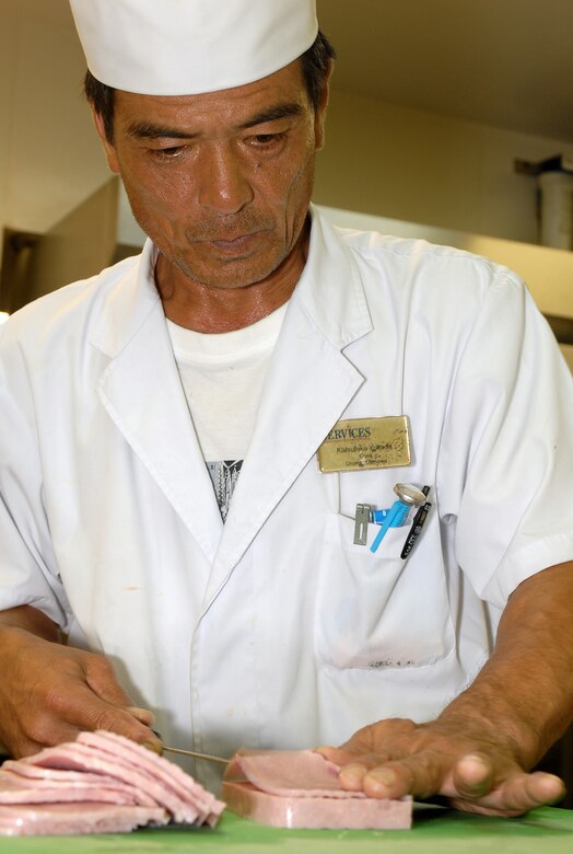 Kalsuhike Yokoda finely slices ham that will be part of the night's dinner selection at the Marshall Dining Facility ont Kadena Air Base, Japan, Aug. 15, 2007.  The dining facility serves three meals to around 1,000 U.S. military members daily.  Mr. Yokoda is a cook at the Marshall Dining Facility.  (U.S. Air Force photo/Airman 1st Class Kelly Timney)