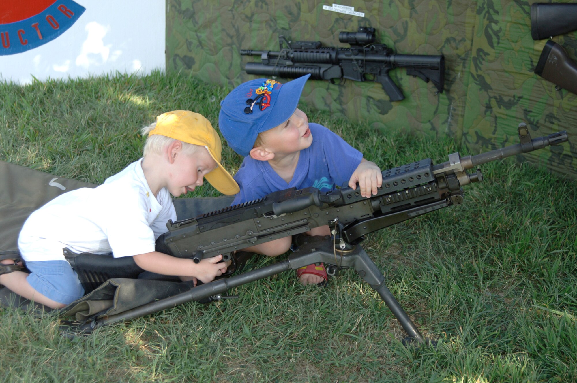 MCCONNELL AIR FORCE BASE, Kan. -- Matthew Goodner, left, 2, and John Goodner, 4, play with a display M-240 machine gun at the 22nd Security Forces Squadron’s National Night Out event here Aug. 7. National Night Out is an annual event held by law enforcement agencies across the nation. The event’s goal is to provide community members a safe and fun environment in which they can learn about crime and drug prevention. It is also designed to generate community support in anticrime programs and foster partnerships between local law enforcement organizations and the public. (Photo by Airman 1st Class Laura Suttles)