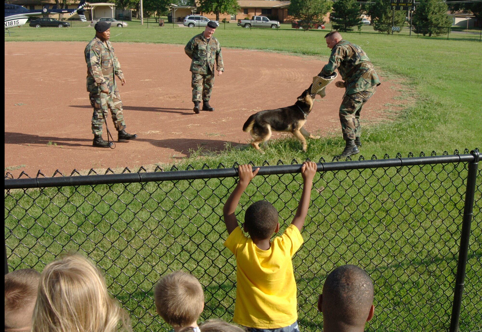 Senior Airman Chad Ditch, 22 Security Forces Squadron, and Gypsy, a 22nd SFS military working dog, perform a K-9 demonstration for a crowd of onlookers at the 22nd SFS National Night Out event here Aug. 7. National Night Out is an annual event held by law enforcement agencies across the nation. The event’s goal is to provide community members a safe and fun environment in which they can learn about crime and drug prevention. It is also designed to generate community support in anticrime programs and foster partnerships between local law enforcement organizations and the public. (Photo by Airman 1st Class Laura Suttles)