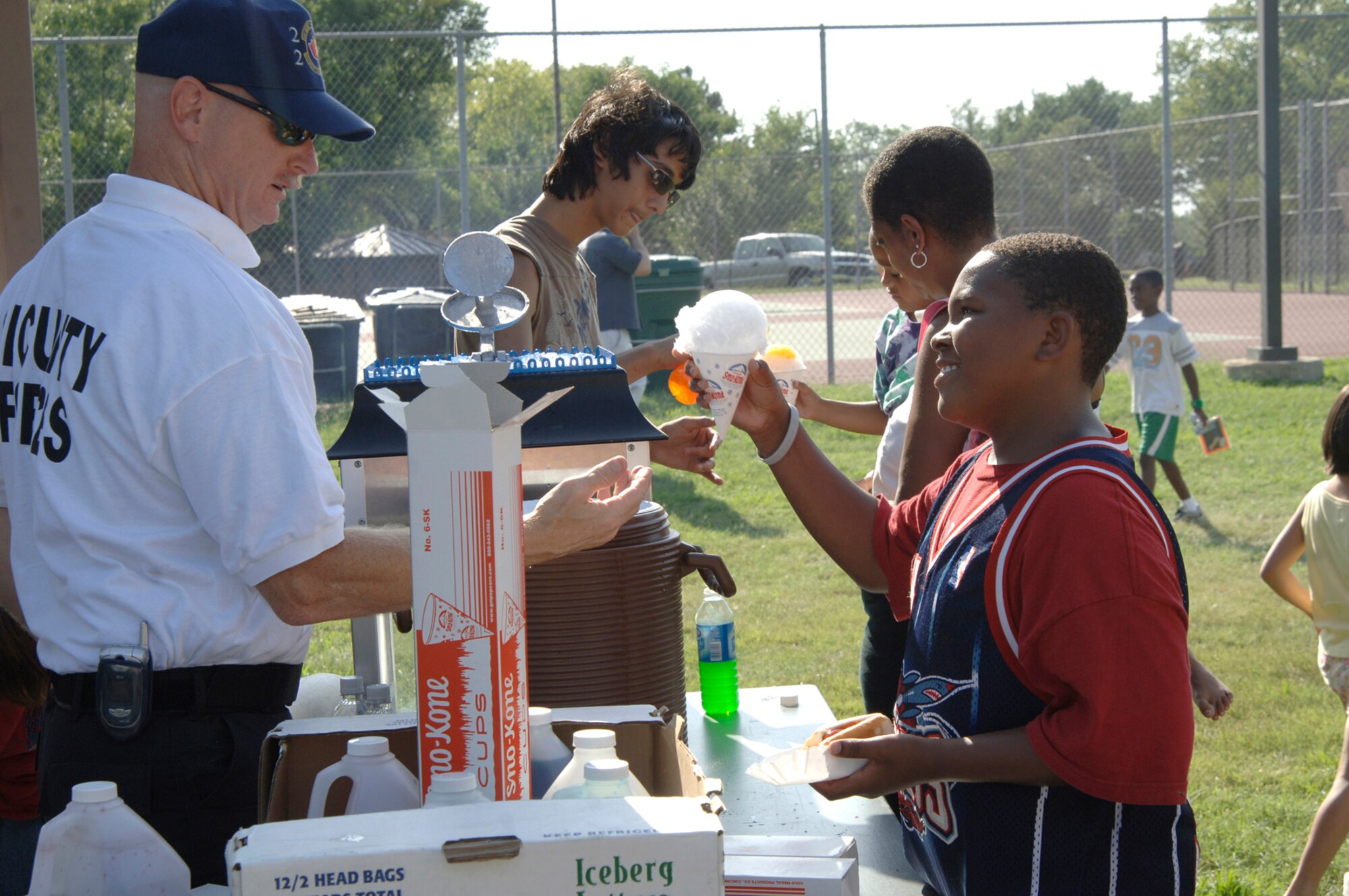 Master Sgt. Dan Bryant, 22nd Security Forces Squadron, hands out snow cones at the 22nd SFS National Night Out event here Aug. 7. National Night Out is an annual event held by law enforcement agencies across the nation. The event’s goal is to provide community members a safe and fun environment in which they can learn about crime and drug prevention. It is also designed to generate community support in anticrime programs and foster partnerships between local law enforcement organizations and the public. (Photo by Airman 1st Class Laura Suttles)
