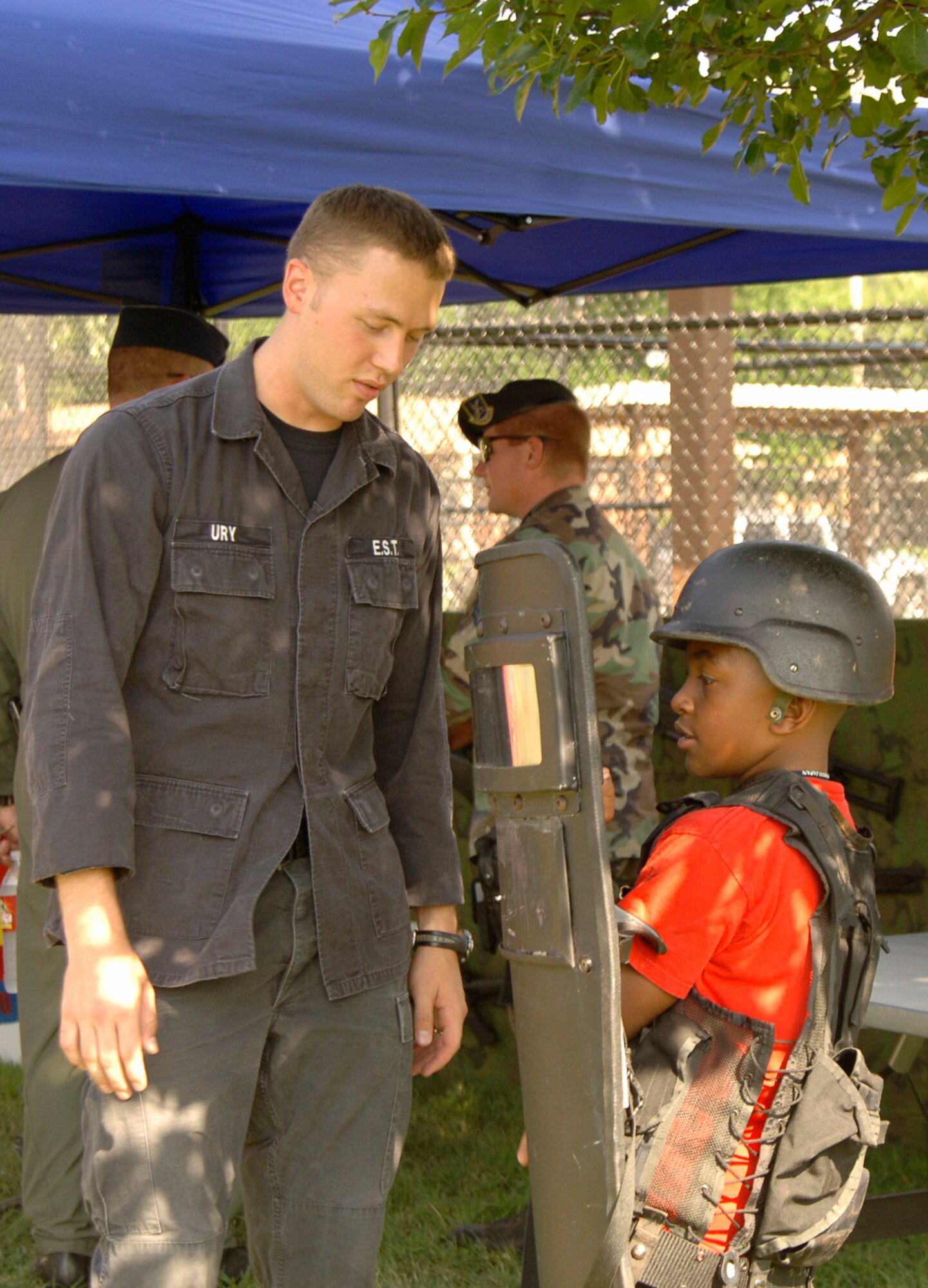 MCCONNELL AIR FORCE BASE, Kan. -- Senior Airman Scott Ury, 22nd Security Forces Squadron, shows Kevin Brooks, 9, a Team McConnell family member, how to wear body armor at the 22nd SFS National Night Out event here Aug. 7. National Night Out is an annual event held by law enforcement agencies across the nation. The event’s goal is to provide community members a safe and fun environment in which they can learn about crime and drug prevention. It is also designed to generate community support in anticrime programs and foster partnerships between local law enforcement organizations and the public. (Photo by Airman 1st Class Laura Suttles)